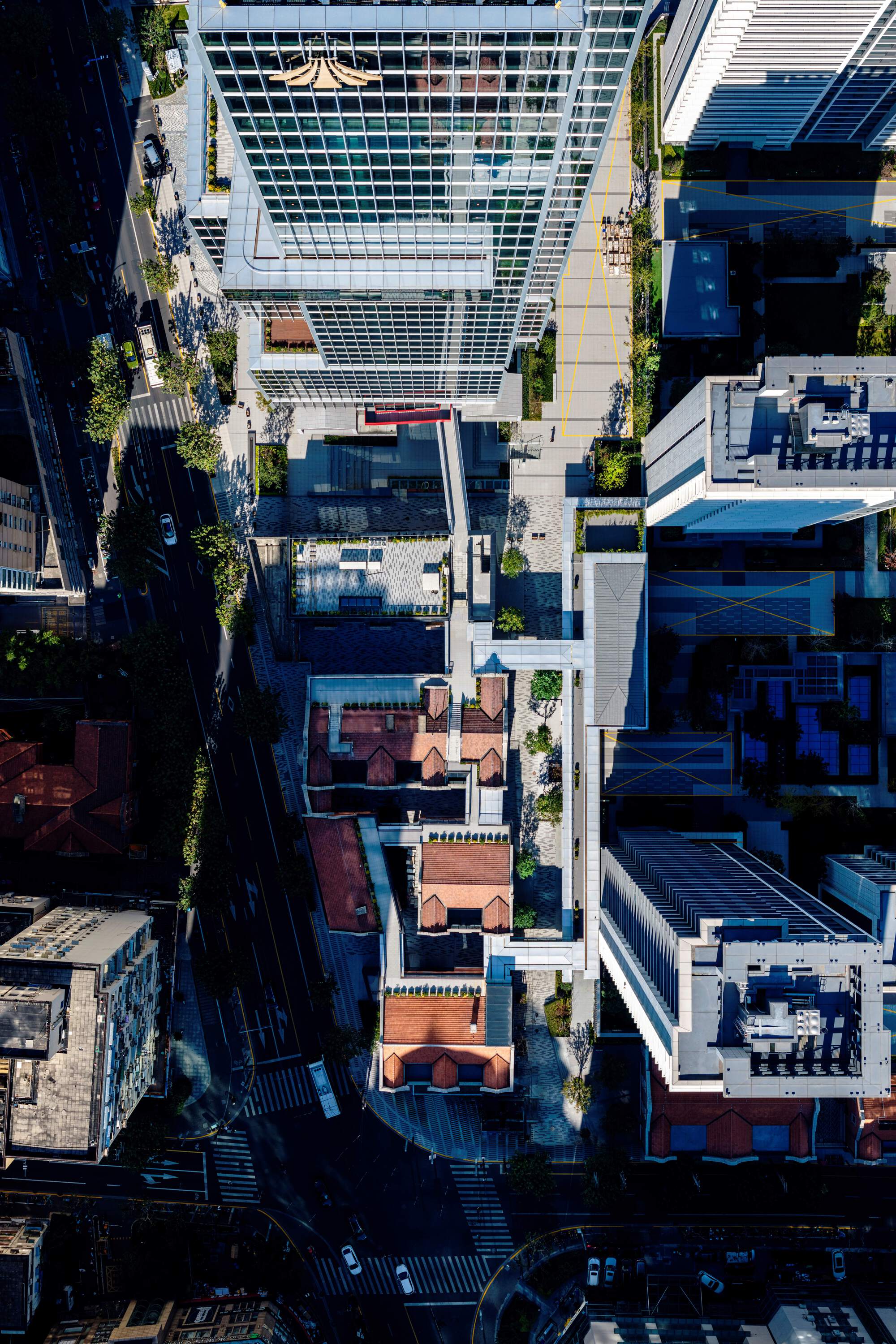 Drone view of the striped glass tower rising among restored heritage rooftops and tree-lined streets