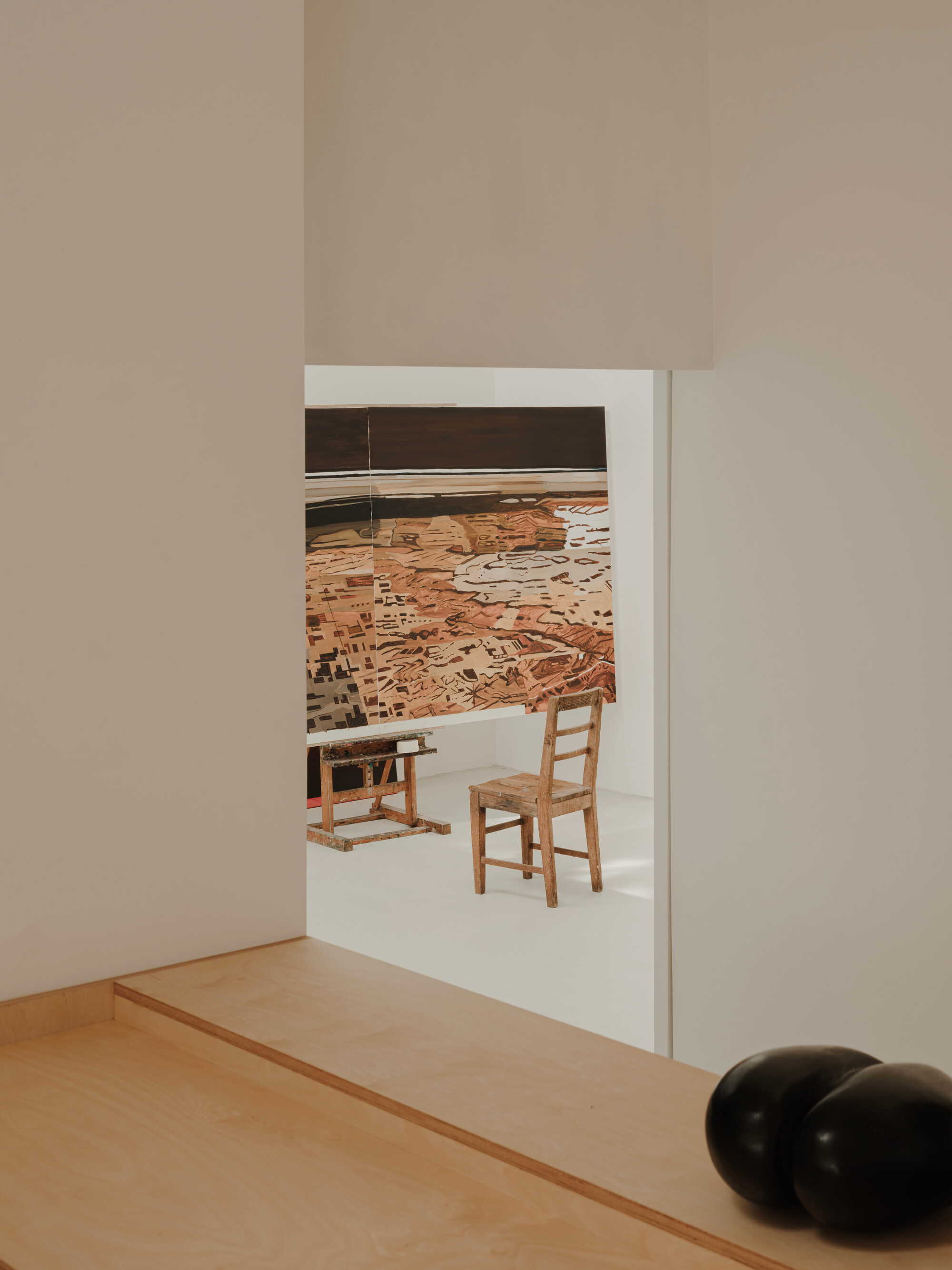 Doorway framing a view through to a room with timber furniture and a large abstract painting