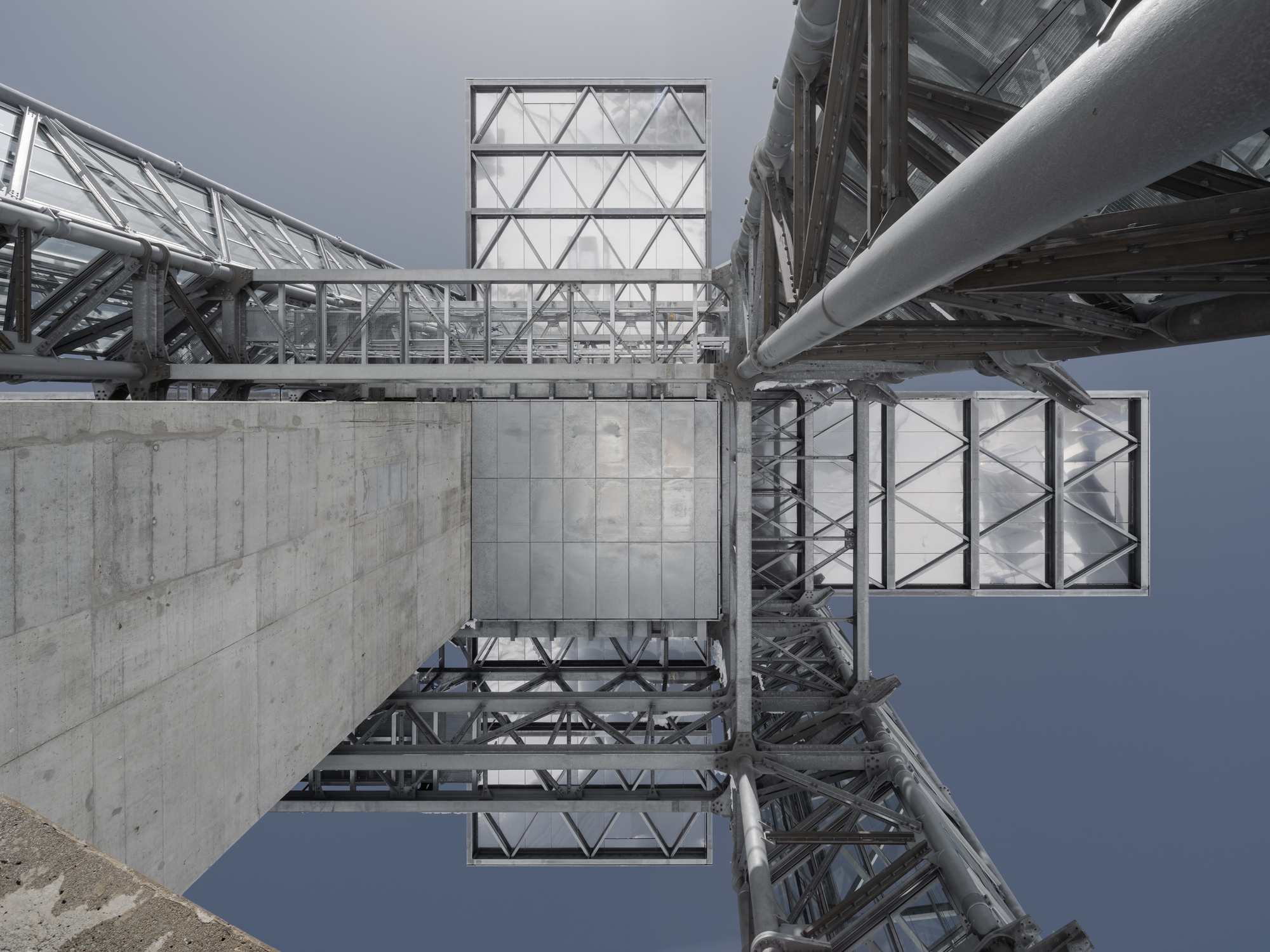 Upward view of the steel lattice structure with concrete base and triangulated glass panels