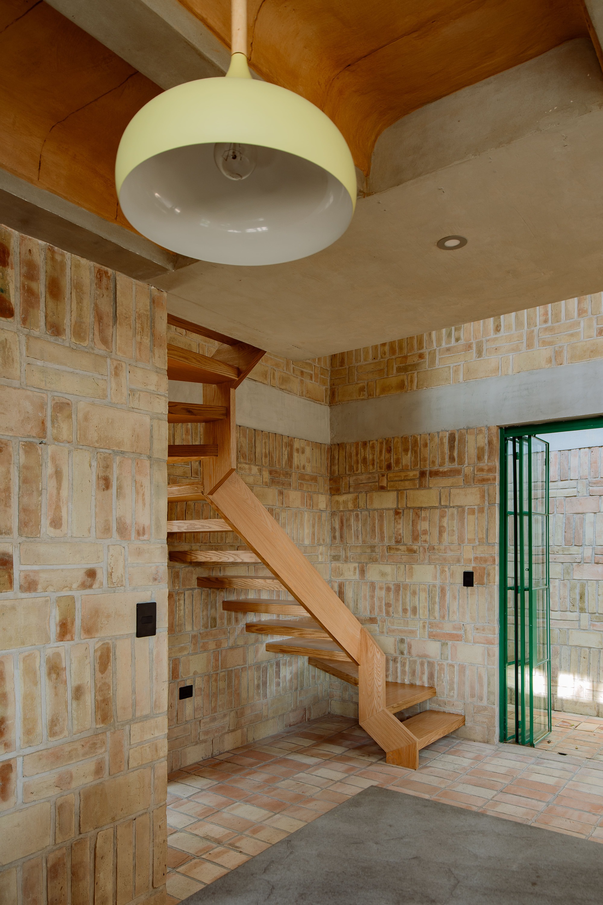 Open timber staircase beneath a white dome pendant light and exposed wood ceiling beams