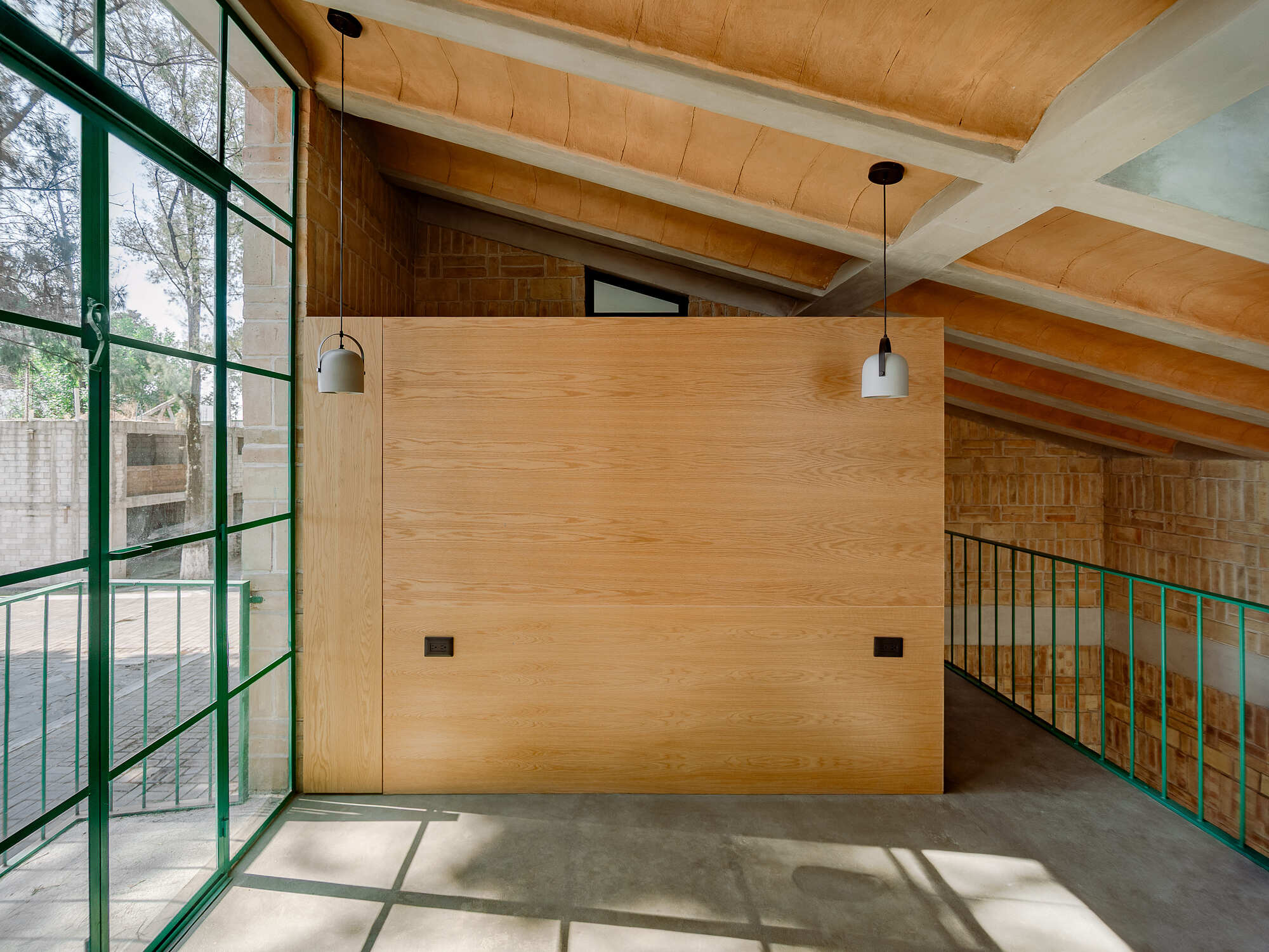 Plywood partition with pendant lights beneath curved timber ceiling and concrete beams