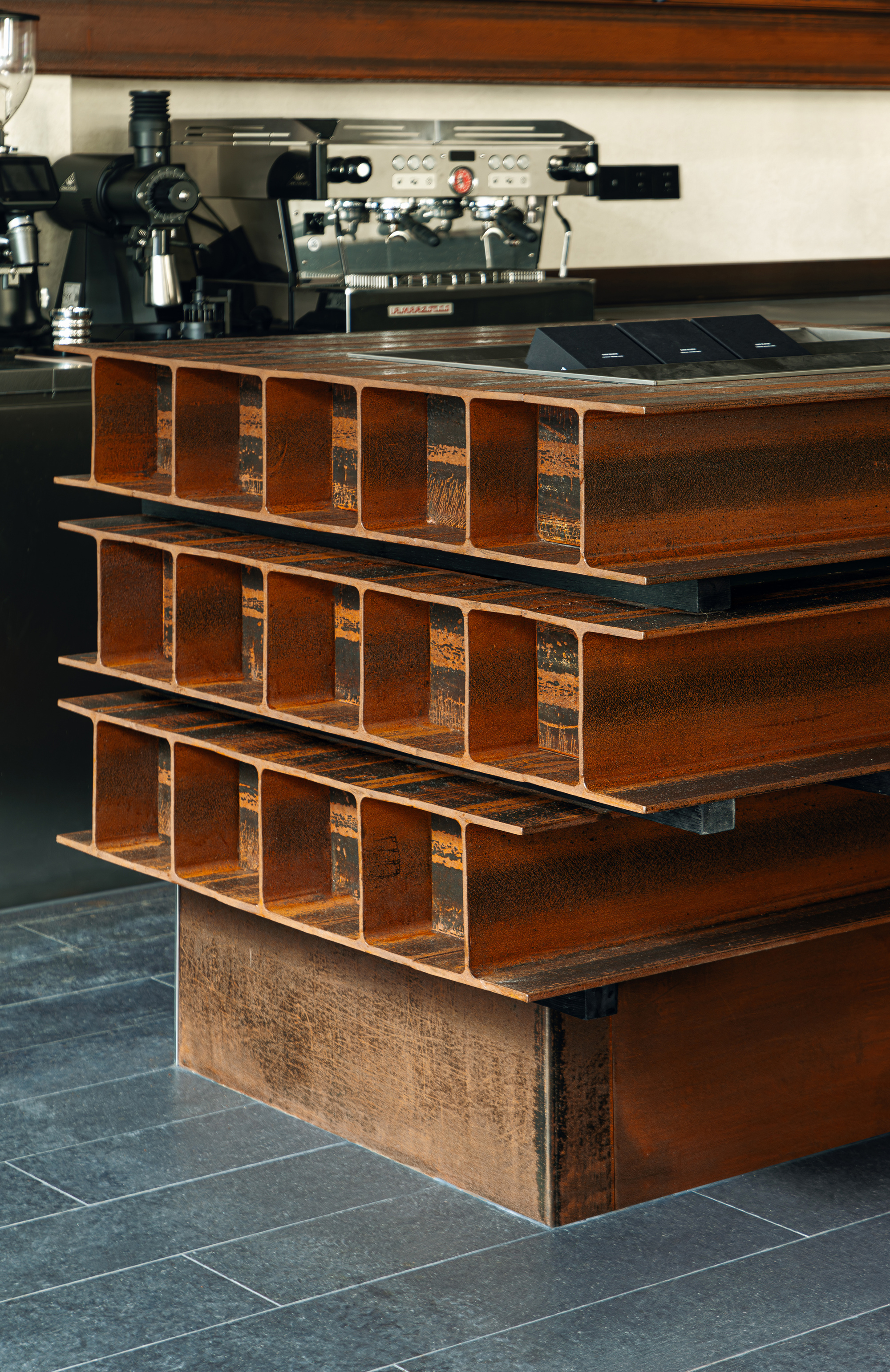 Close-up of stacked timber counter modules with open compartments beneath espresso machines