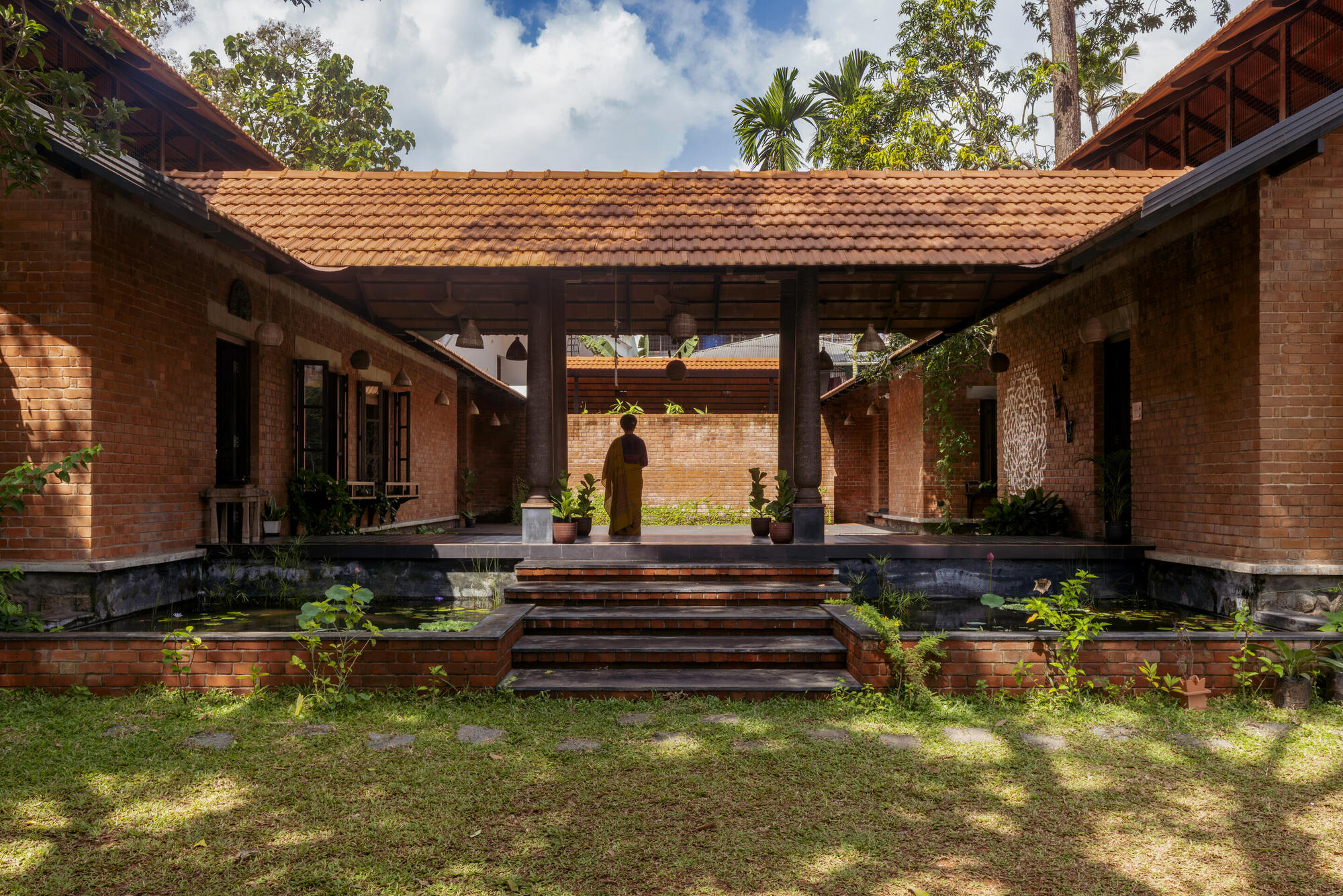 Covered entry stairs leading to a central courtyard with brick walls and timber ceiling structure