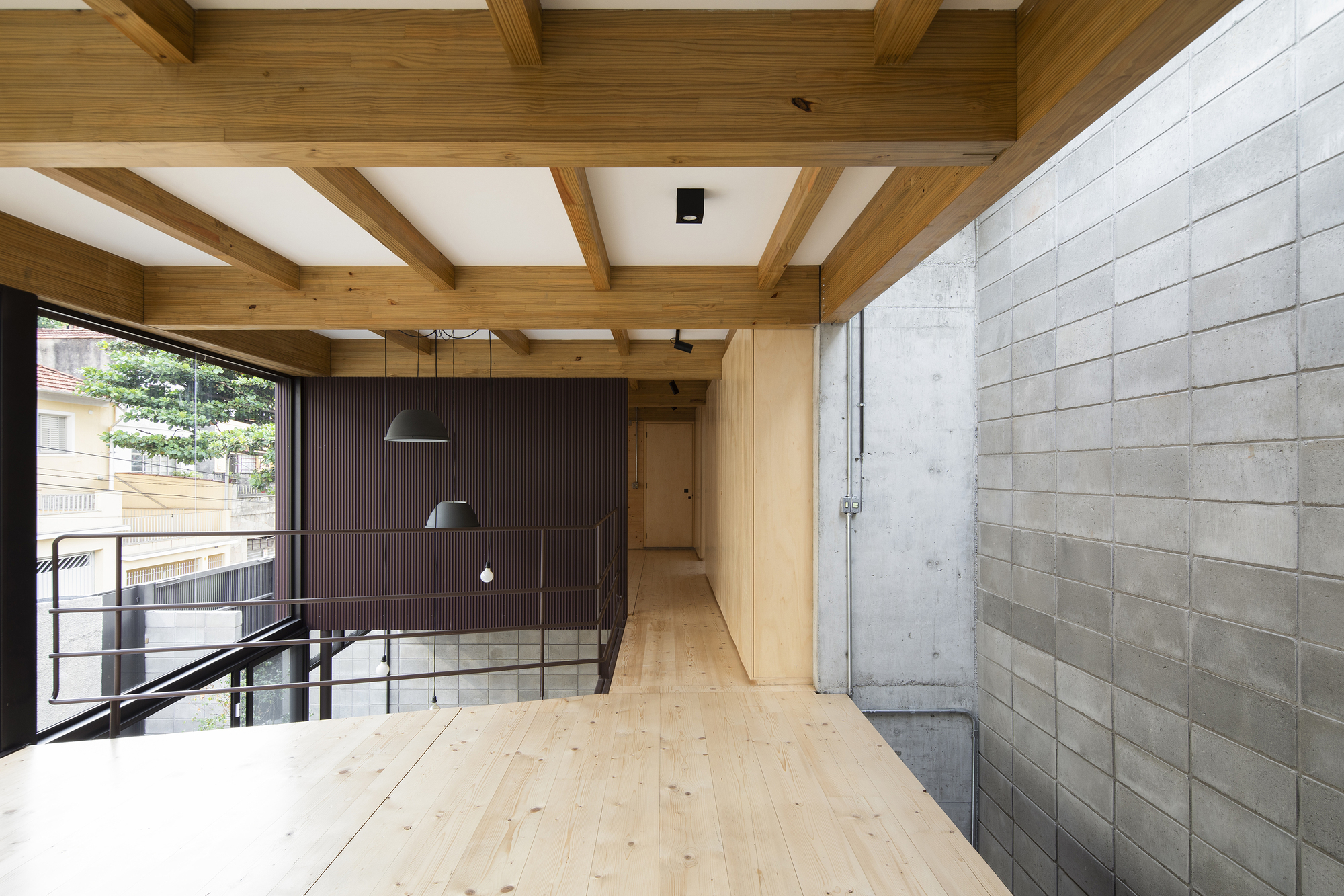 Mezzanine corridor with coffered timber ceiling and concrete block boundary wall