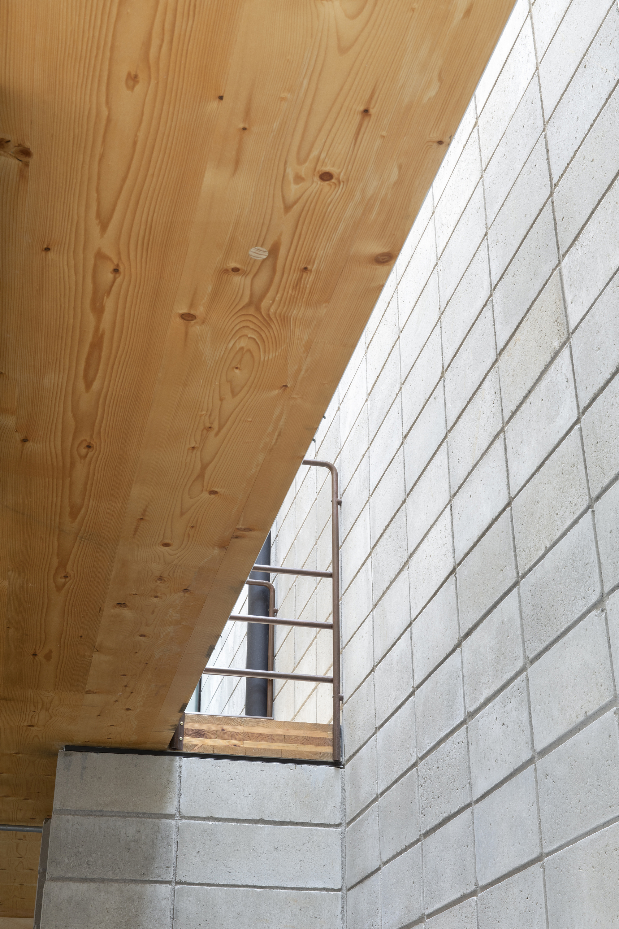 Looking up at the concrete block staircase and plywood soffit with steel guardrail detail