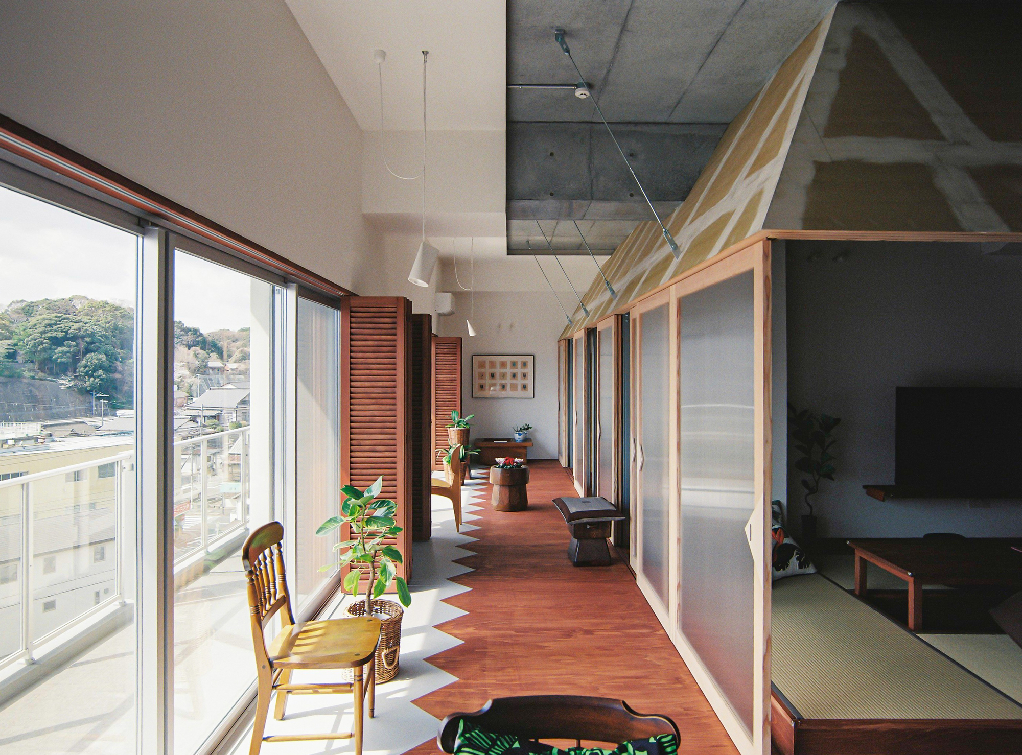 Interior hallway with timber-framed sliding screens and tatami room glimpsed through open doors