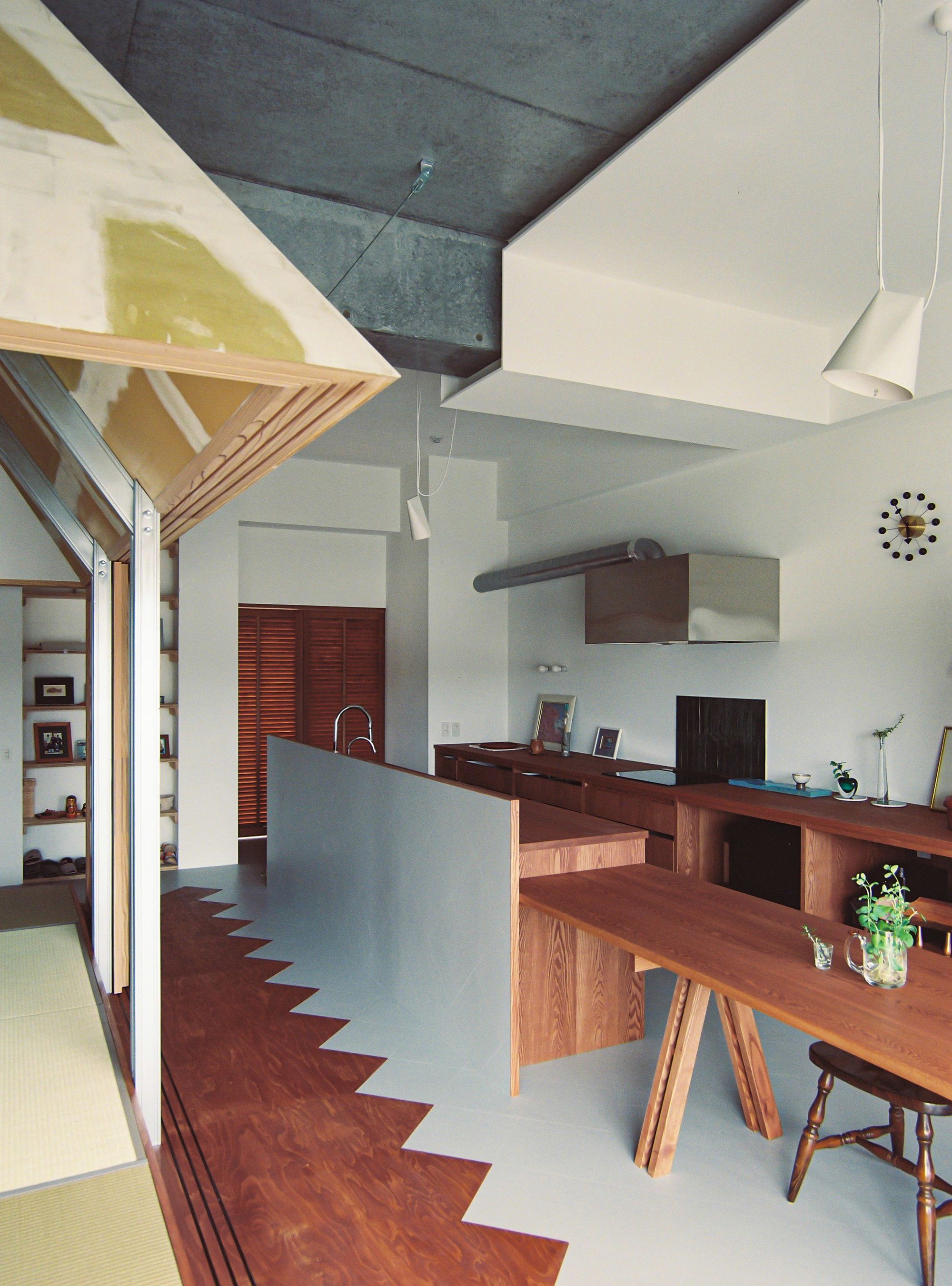 Kitchen and dining area with zigzag floor pattern and plywood truss structure overhead