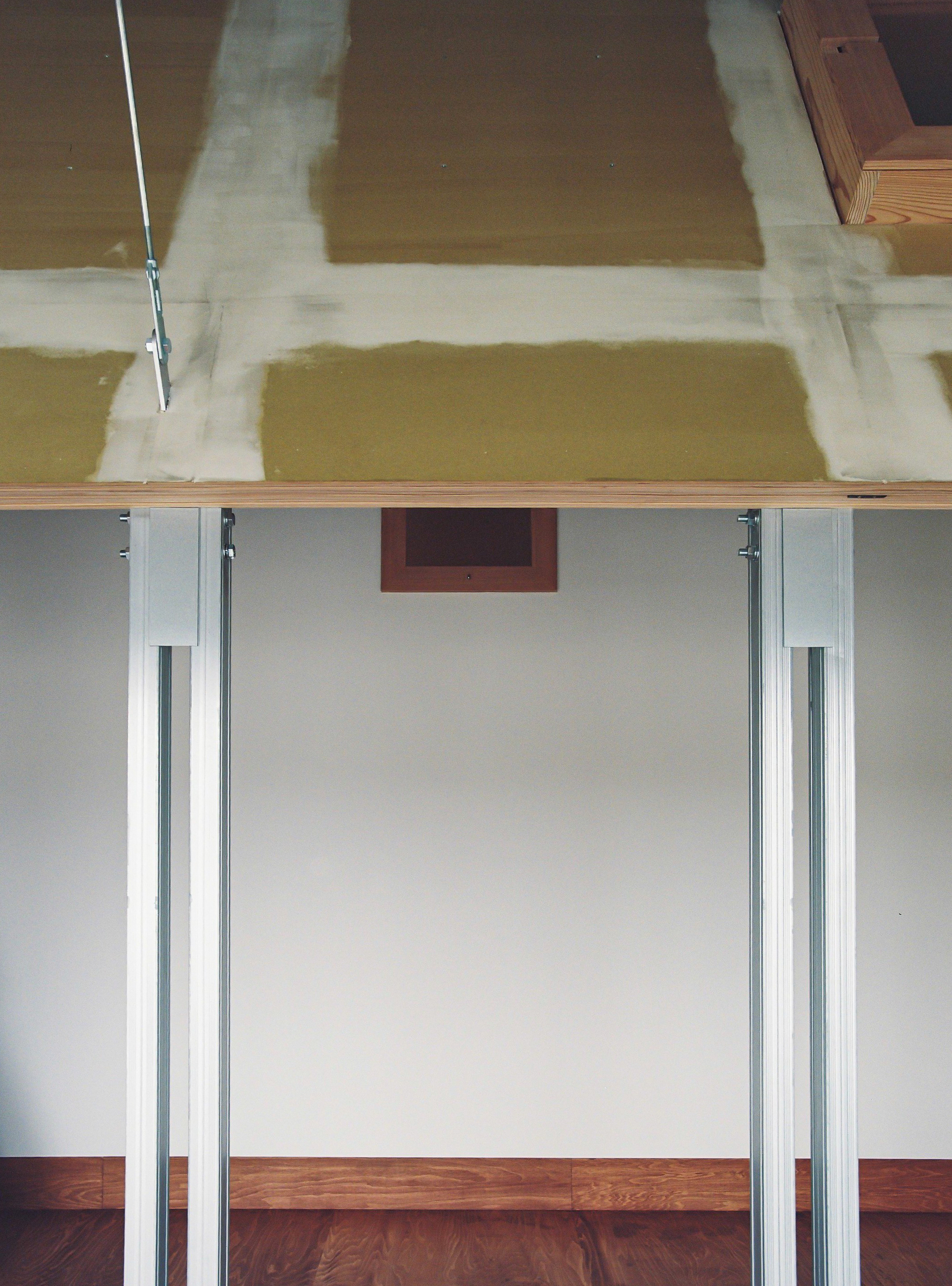 Sliding door hardware and ceiling junction showing the exposed formwork pattern on the overhead concrete surface