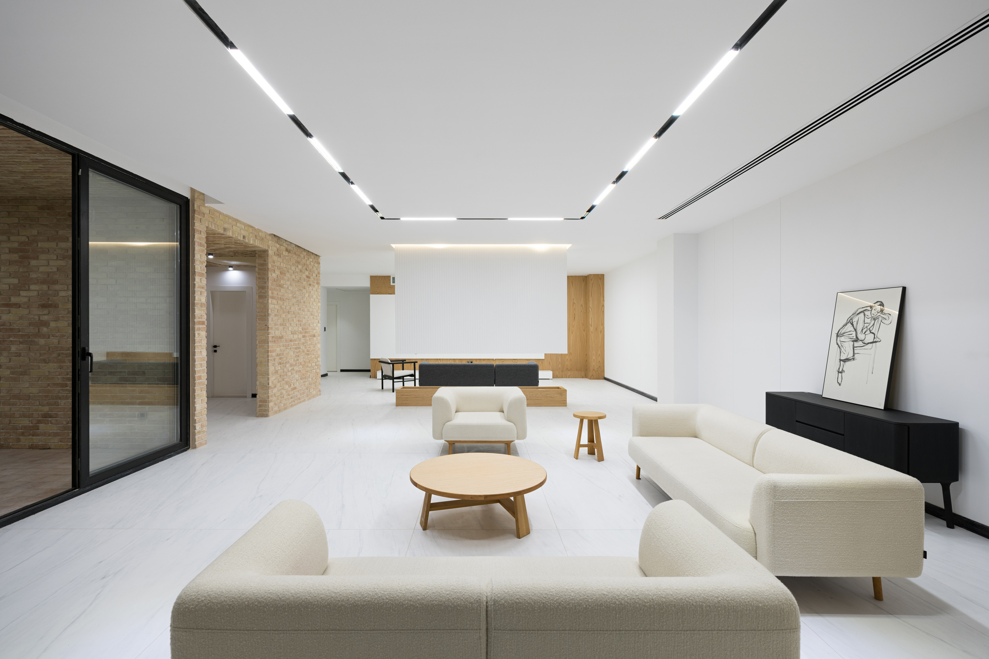 Living room with recessed ceiling lights and textured stone accent wall in daylight