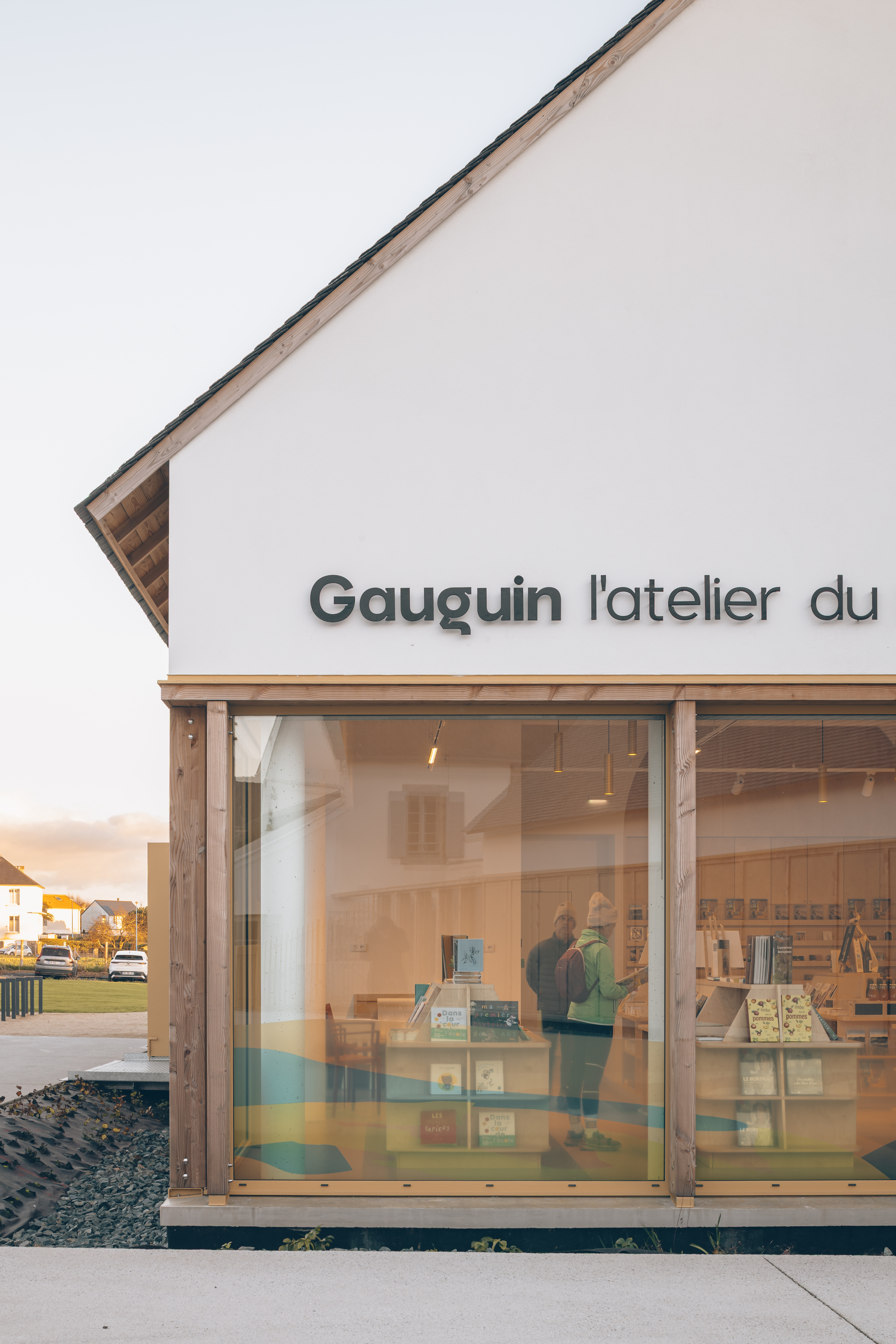 Glazed storefront with timber frame and horizontal striped window decals at dusk
