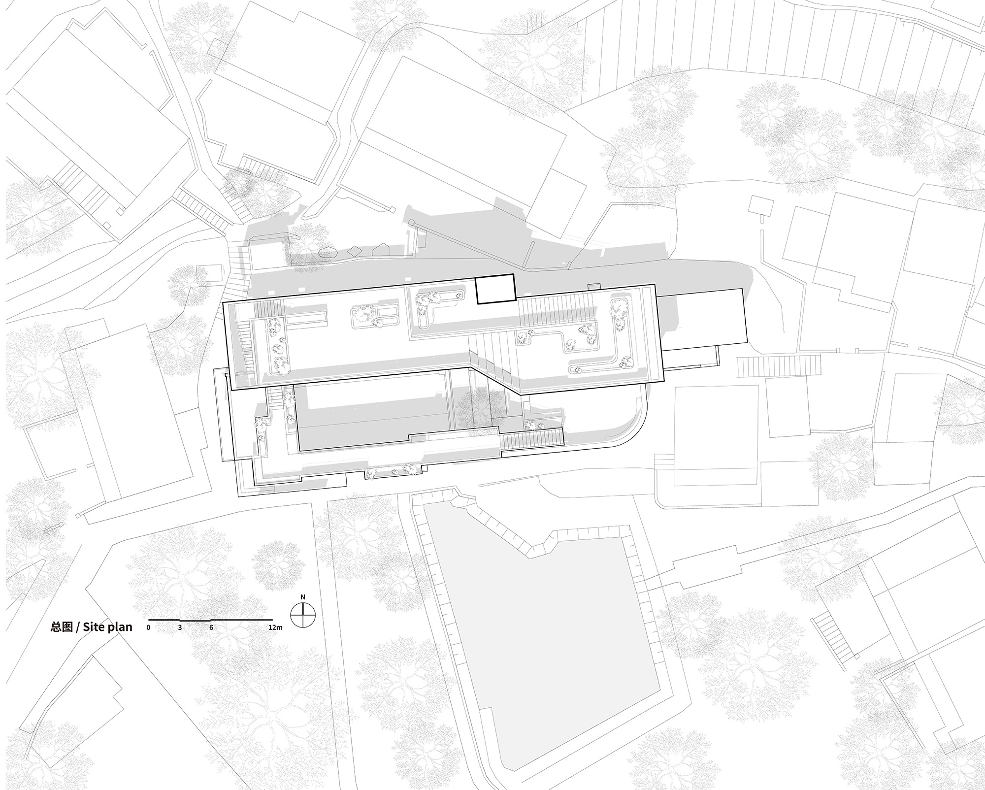 Site plan drawing showing an angular building within a dense urban block with surrounding streets and trees