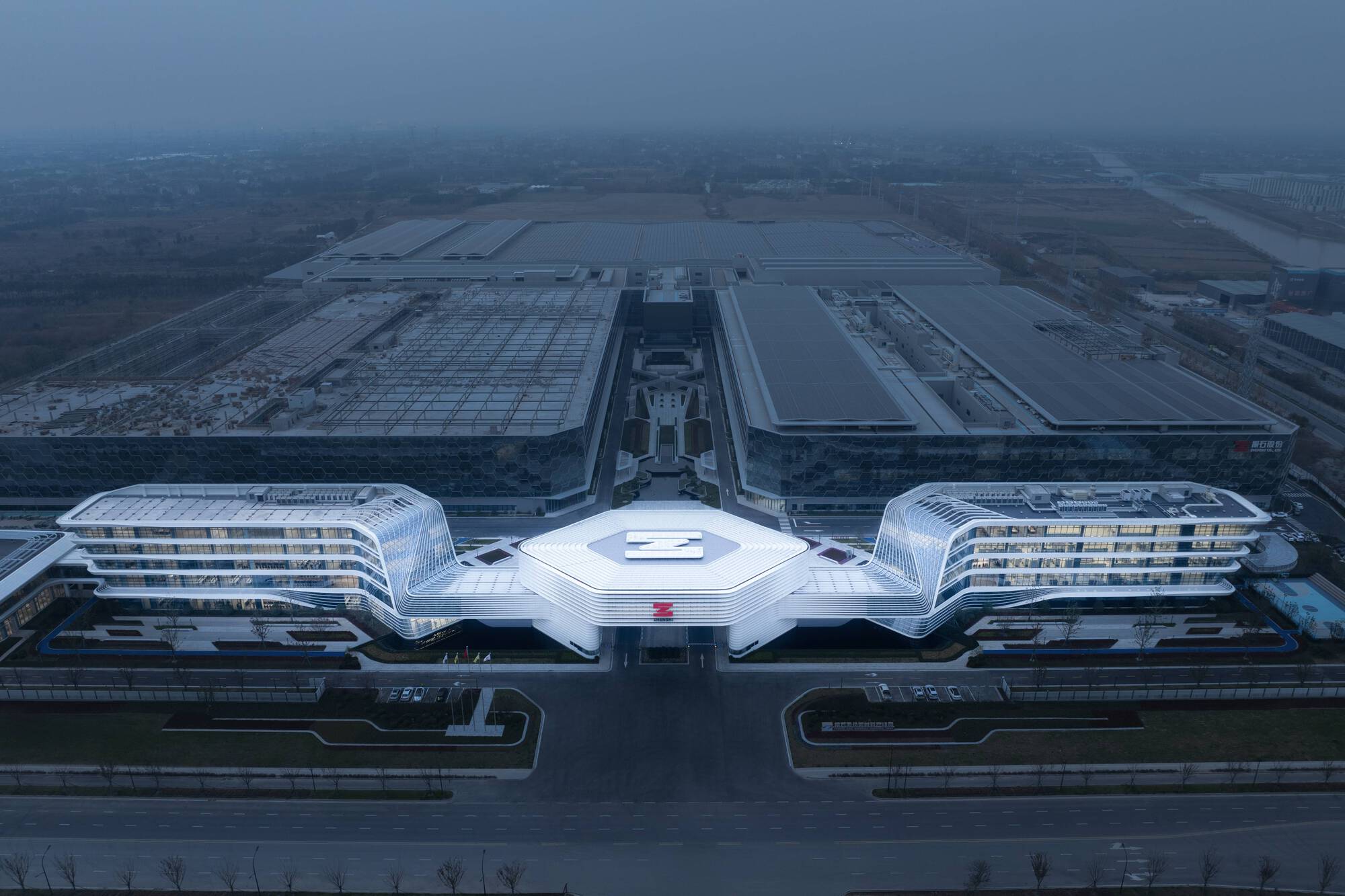 Drone view of the three-winged complex with central hexagonal roof in misty conditions