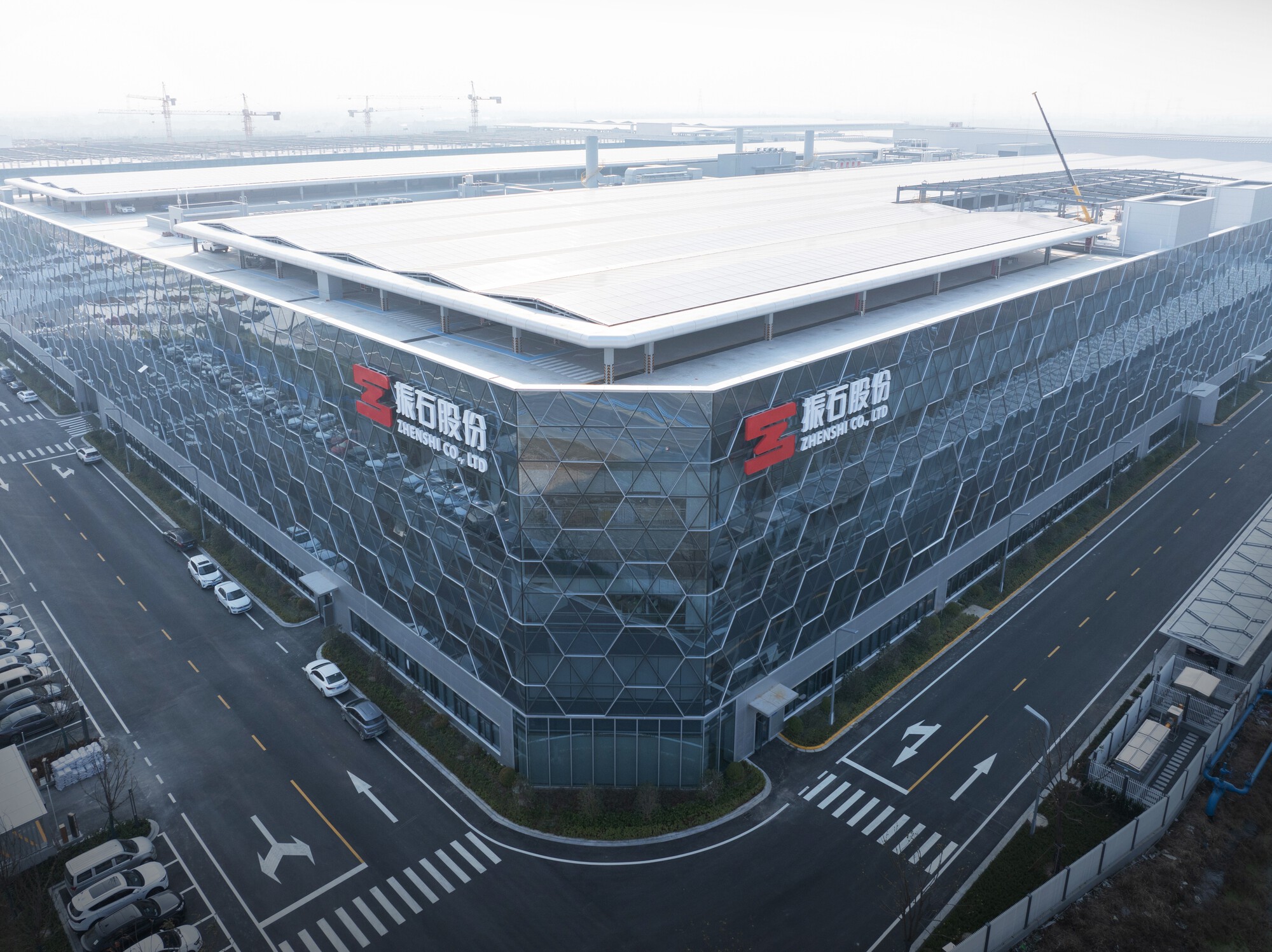 Aerial view of the hexagonal glass facade wrapping the corner of the industrial complex