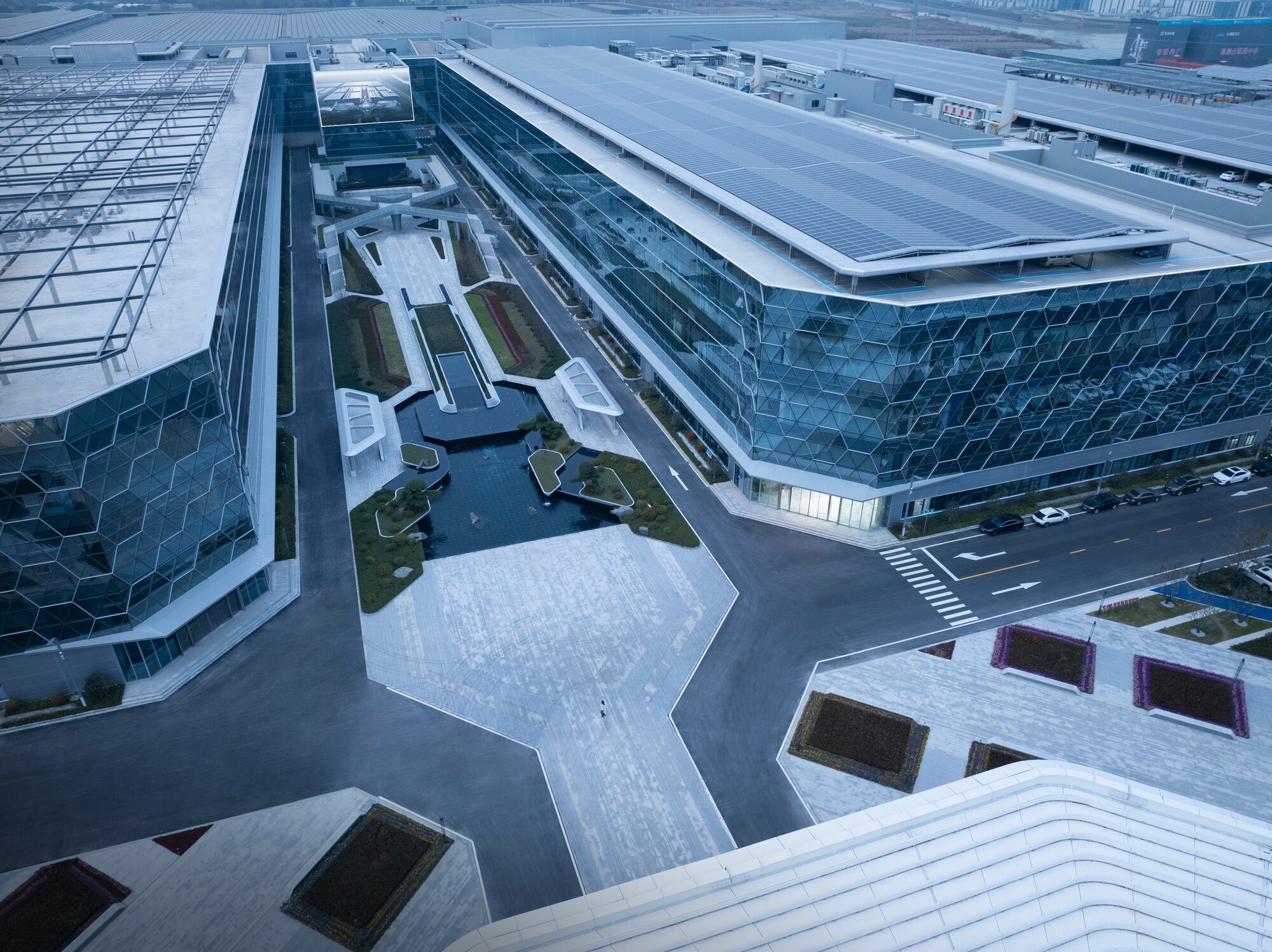 Elevated view of the hexagonal courtyard between two volumes with dark glass facades
