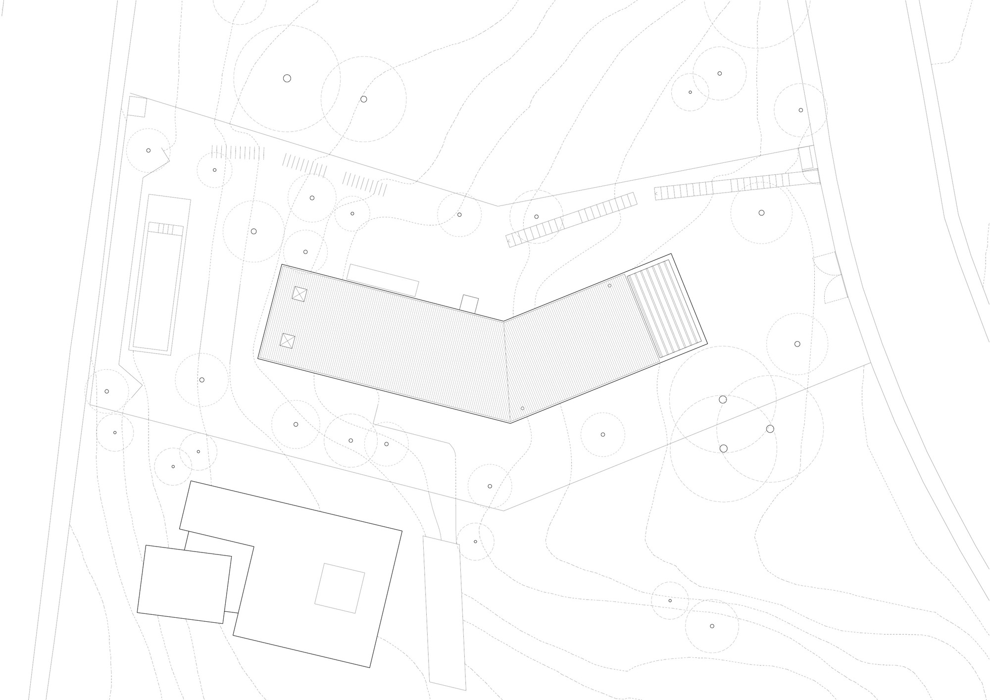 Site plan drawing with angled building volume showing roof detail and surrounding topography with trees
