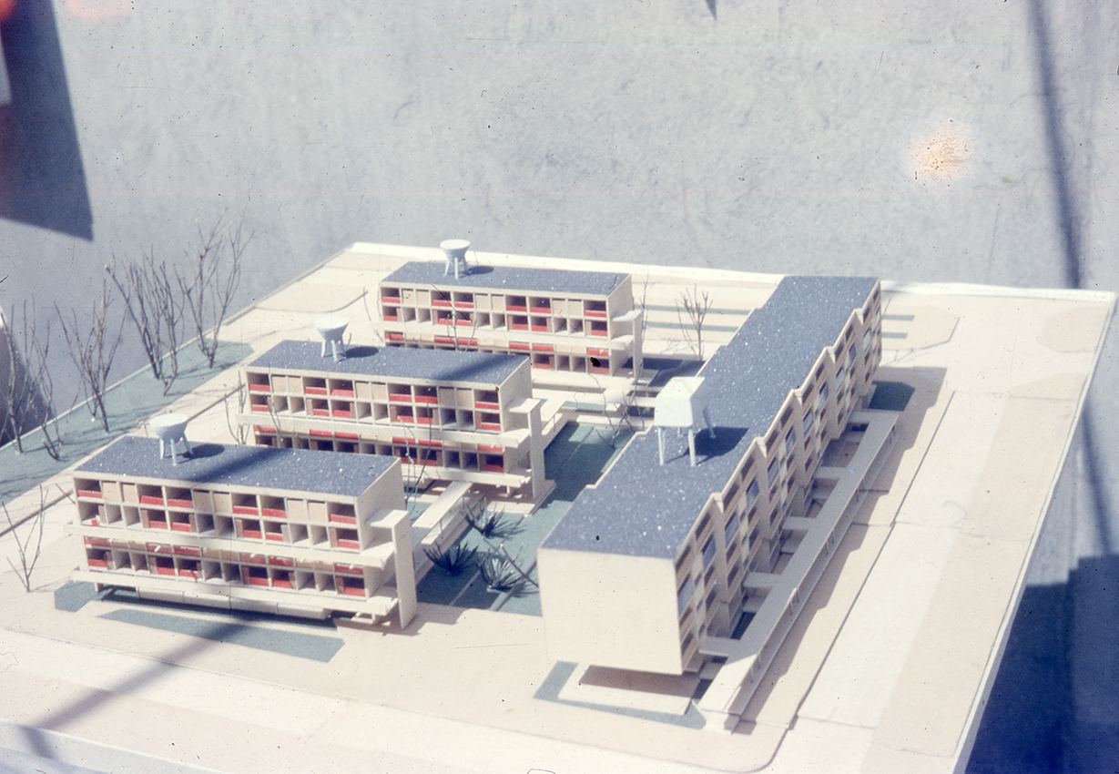 Physical model showing three stepped residential blocks and a linear slab building arranged around a central courtyard