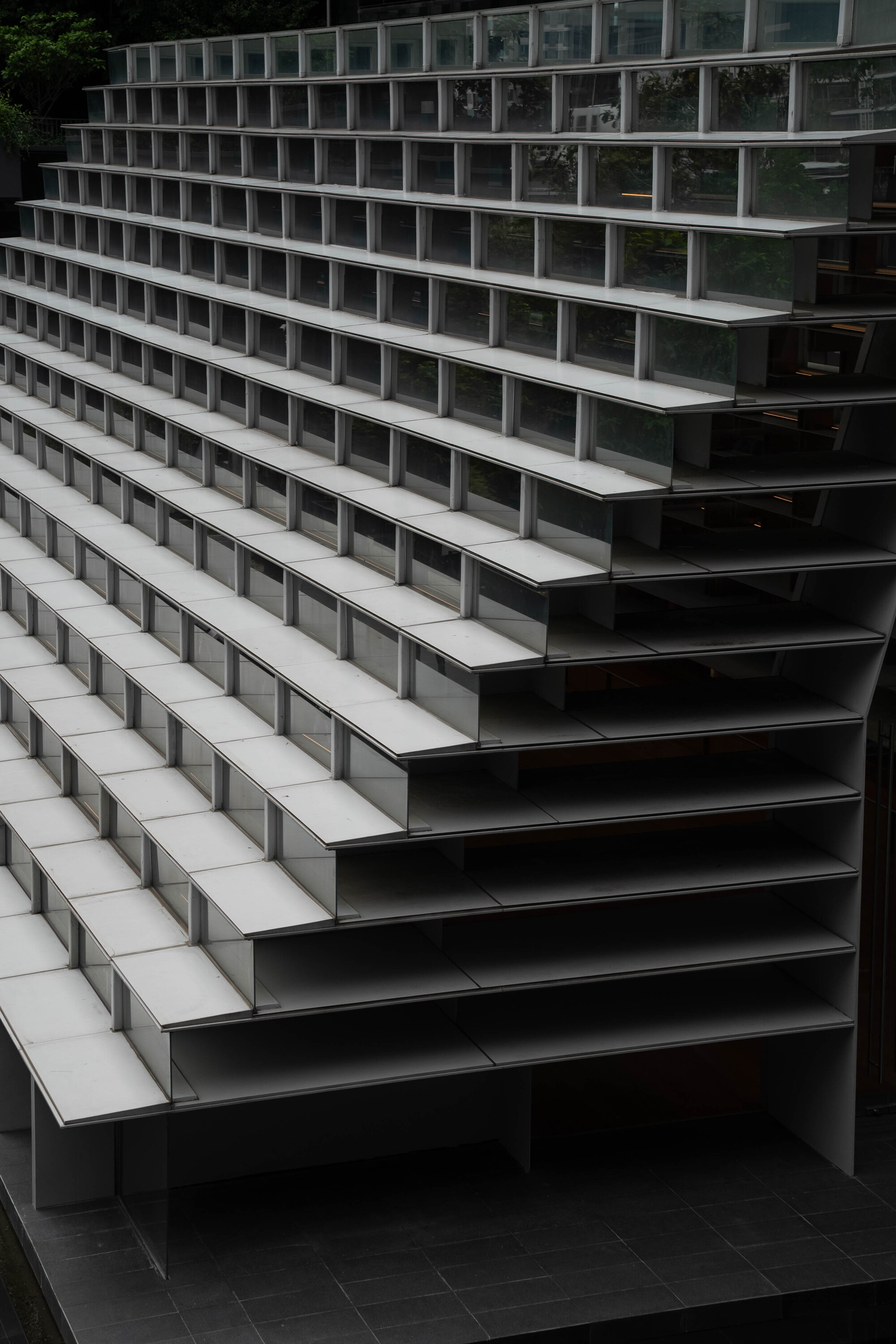 Close-up of terraced seating steps with alternating dark metal risers and pale horizontal treads