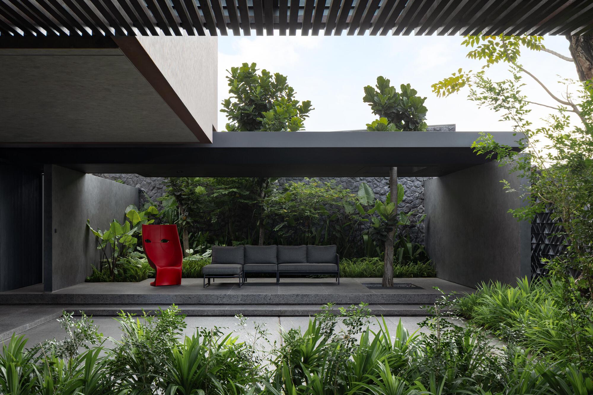Covered terrace with concrete platform and timber pergola overlooking planted garden beds