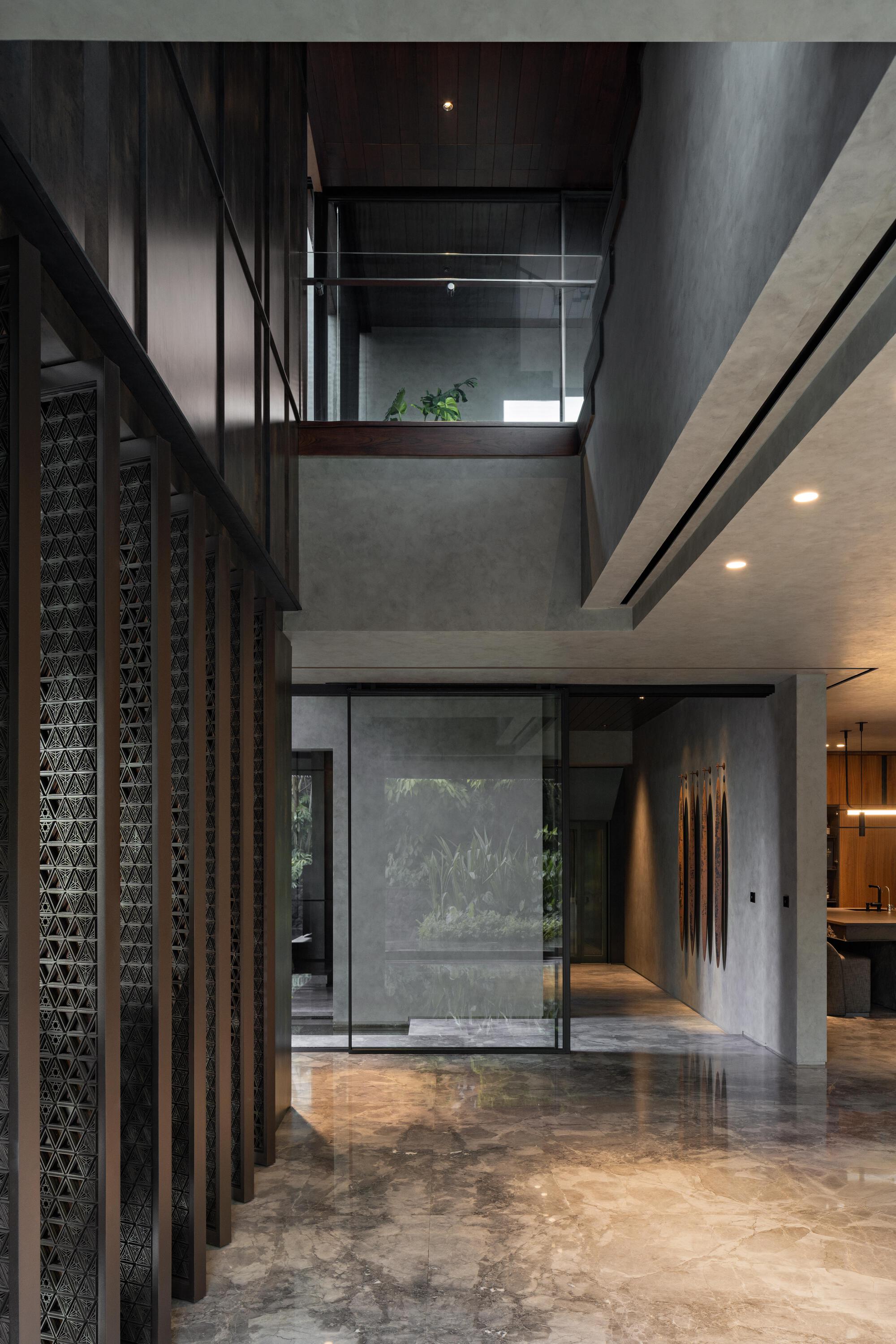 Double-height entrance hall with latticed timber screens and exposed concrete walls