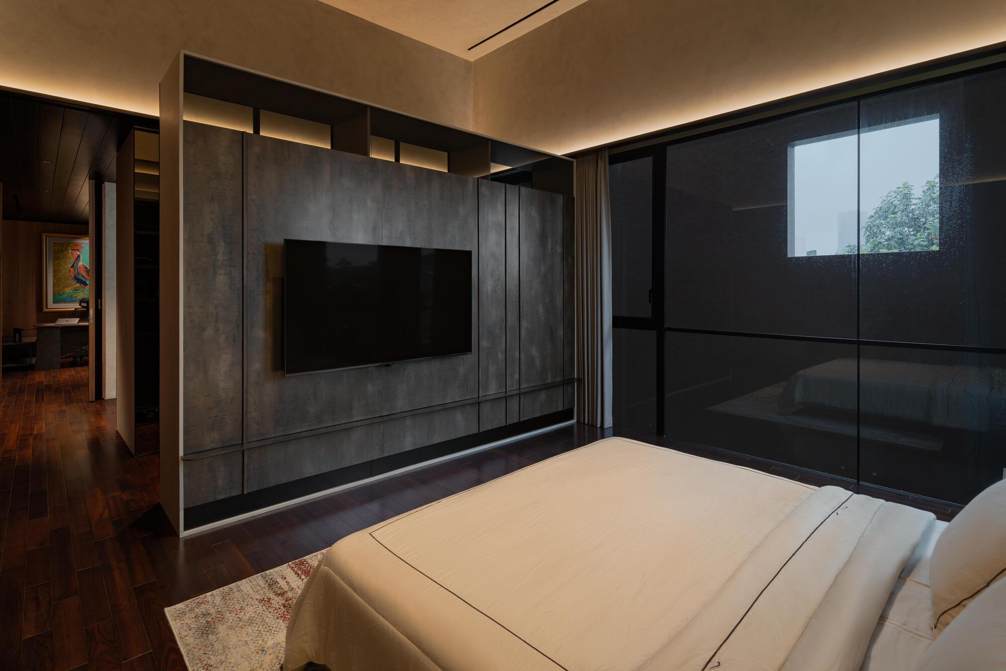 Bedroom with dark textured wall panels and recessed cove lighting at ceiling perimeter