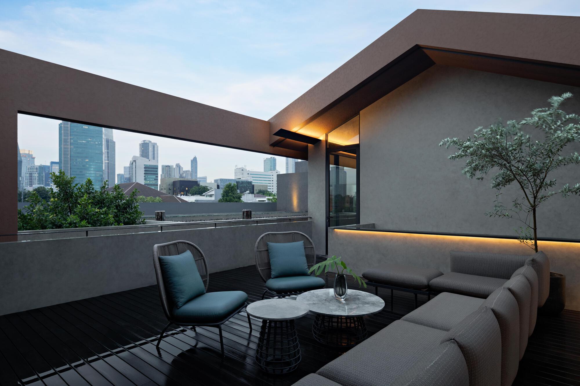 Rooftop terrace with concrete parapet framing views of the skyline at dusk