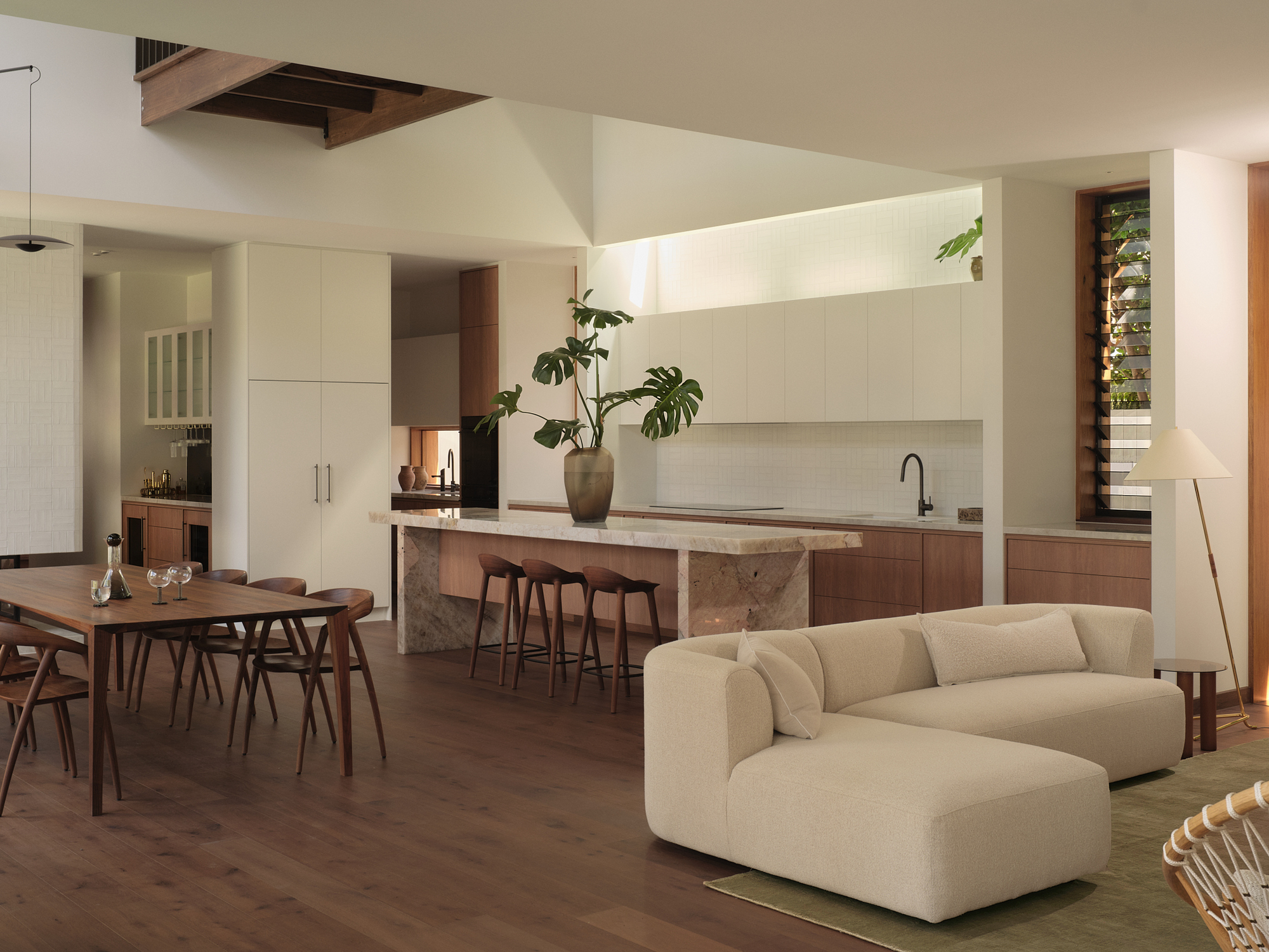 Kitchen and dining area with stone-clad island and skylight opening in the ceiling