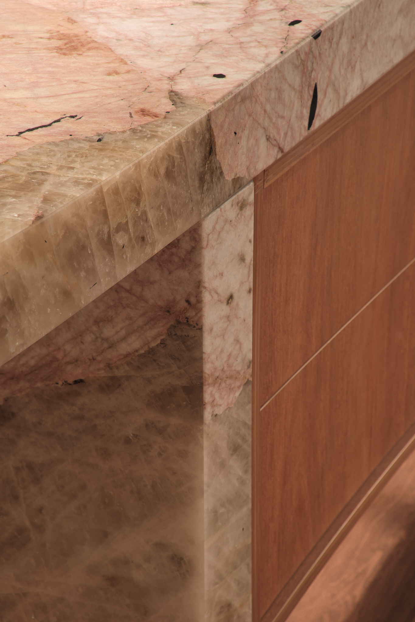 Detail of timber countertop meeting raw plywood cabinetry with visible grain and natural imperfections