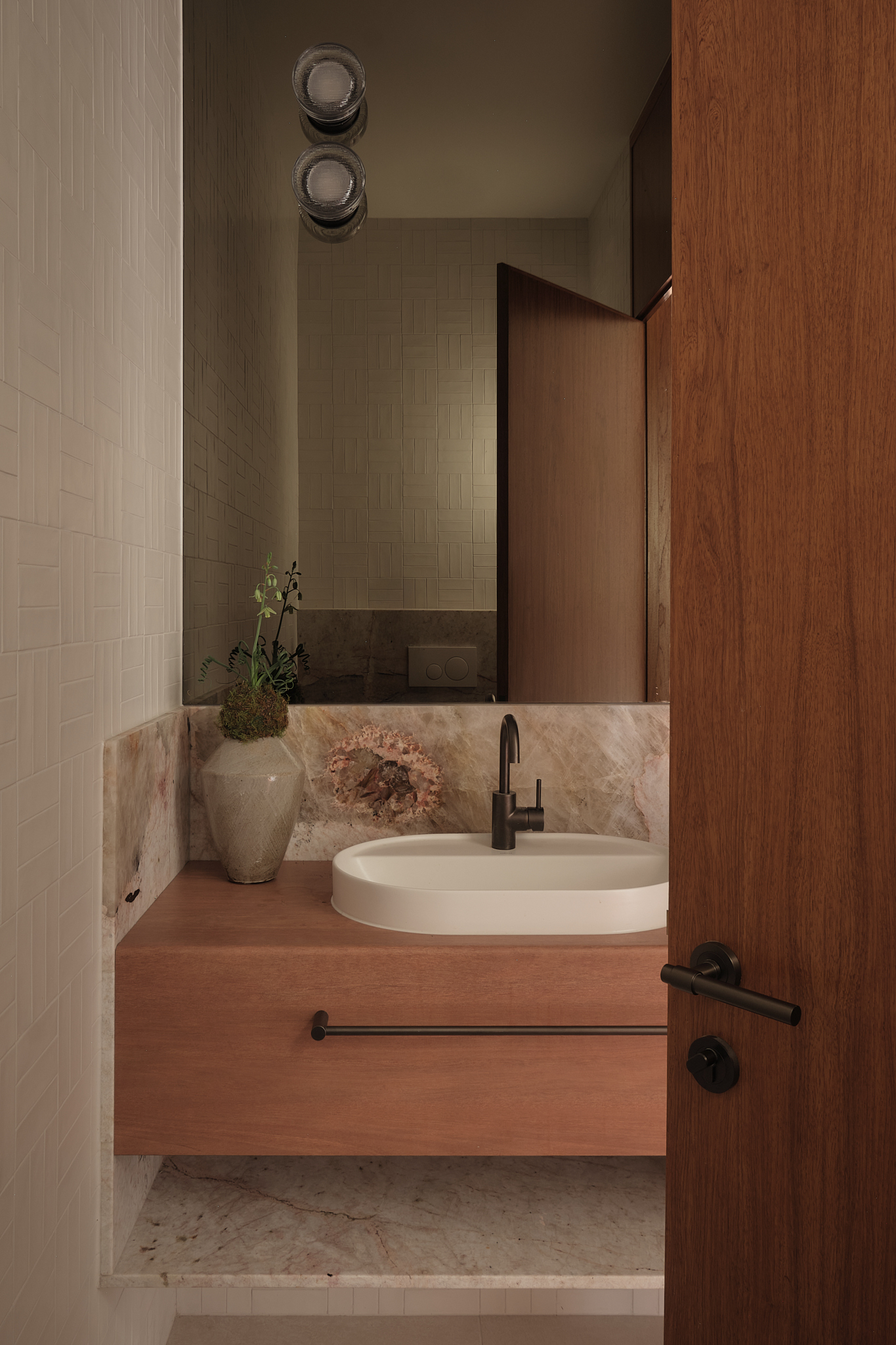 Powder room with floating timber vanity, oval basin, and marbled stone backsplash beneath timber cabinetry