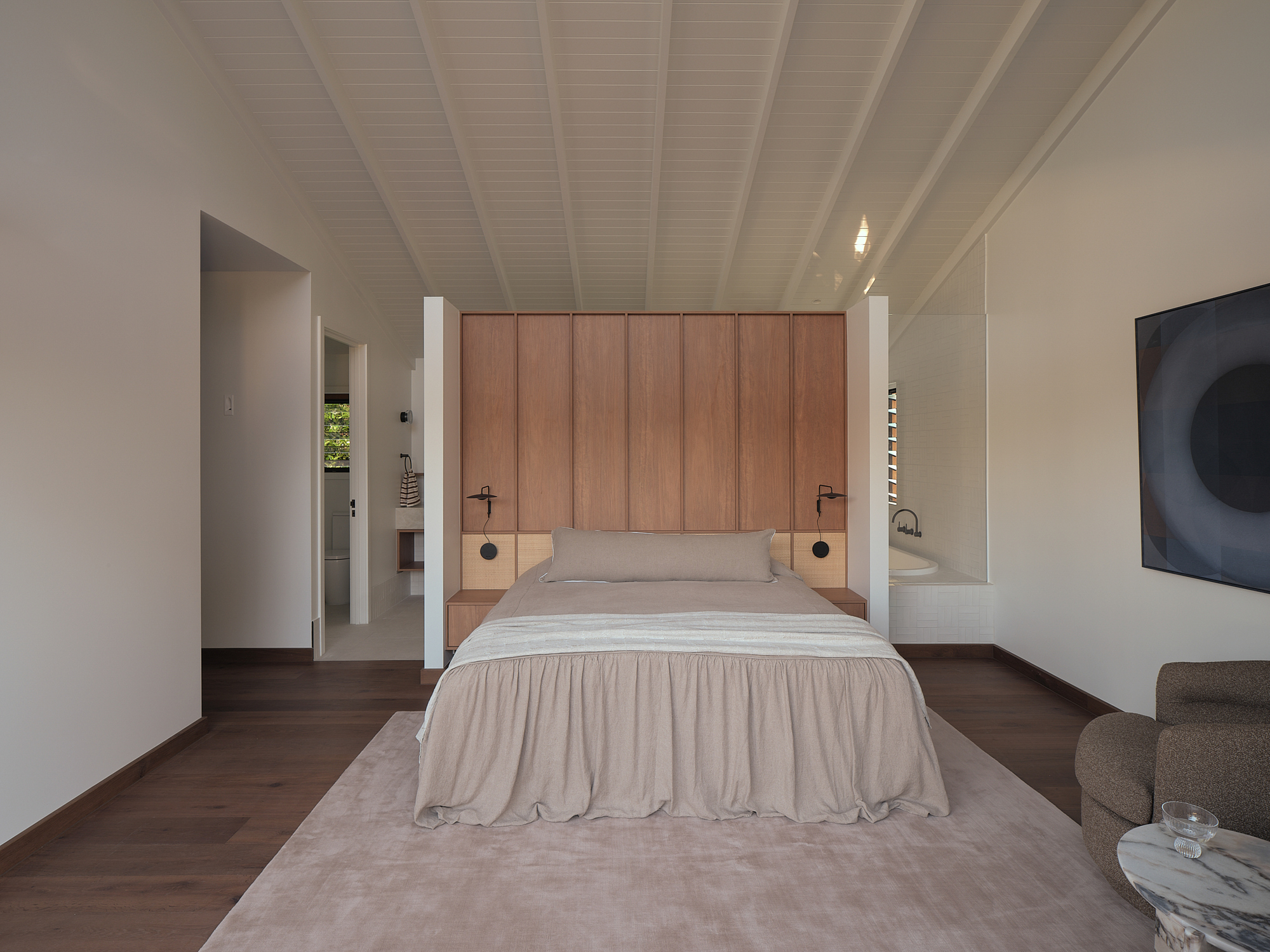 Bedroom with exposed timber ceiling beams, vertical timber headboard wall, and dark timber flooring