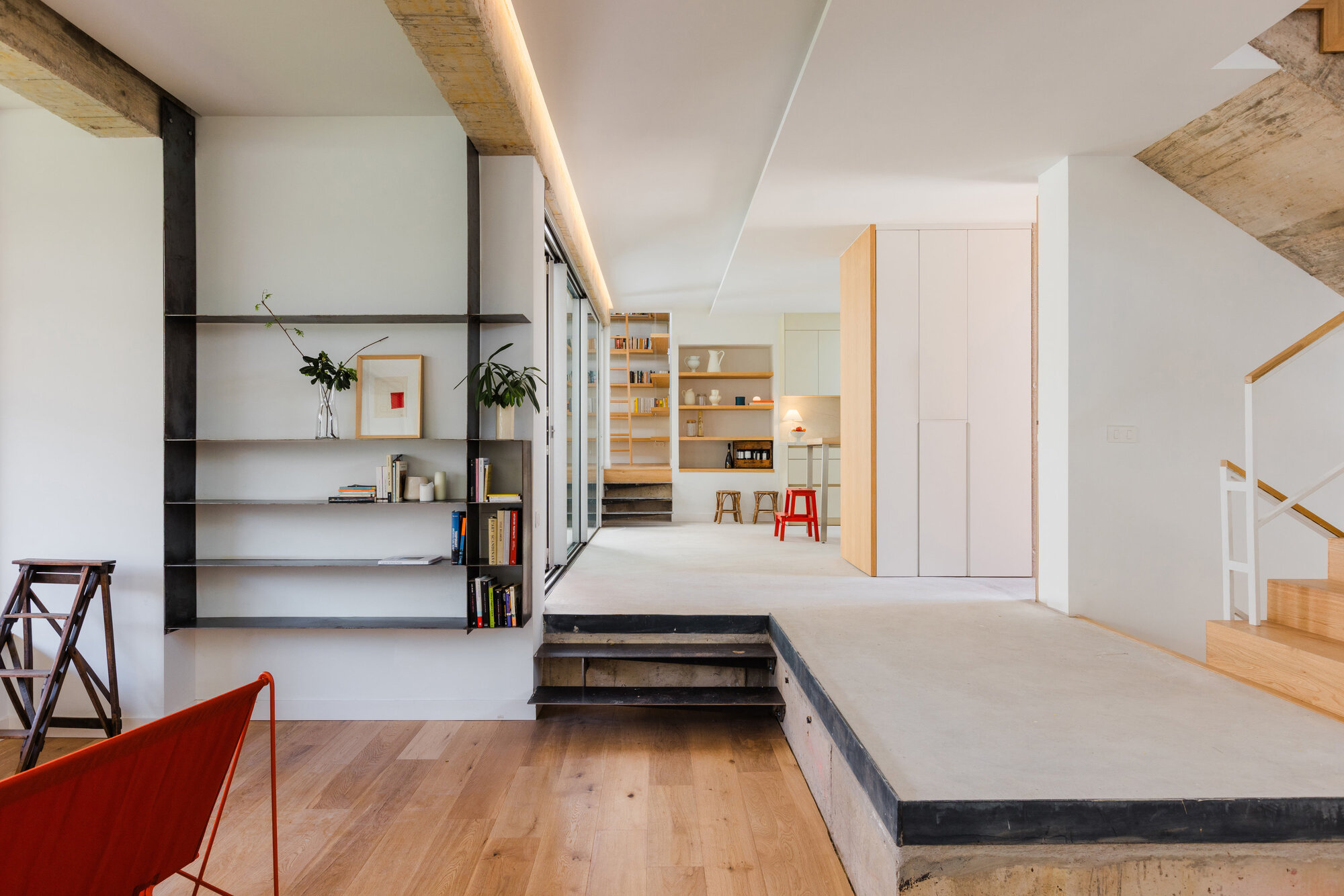 Interior showing open shelving and raised platform with exposed timber ceiling beams above