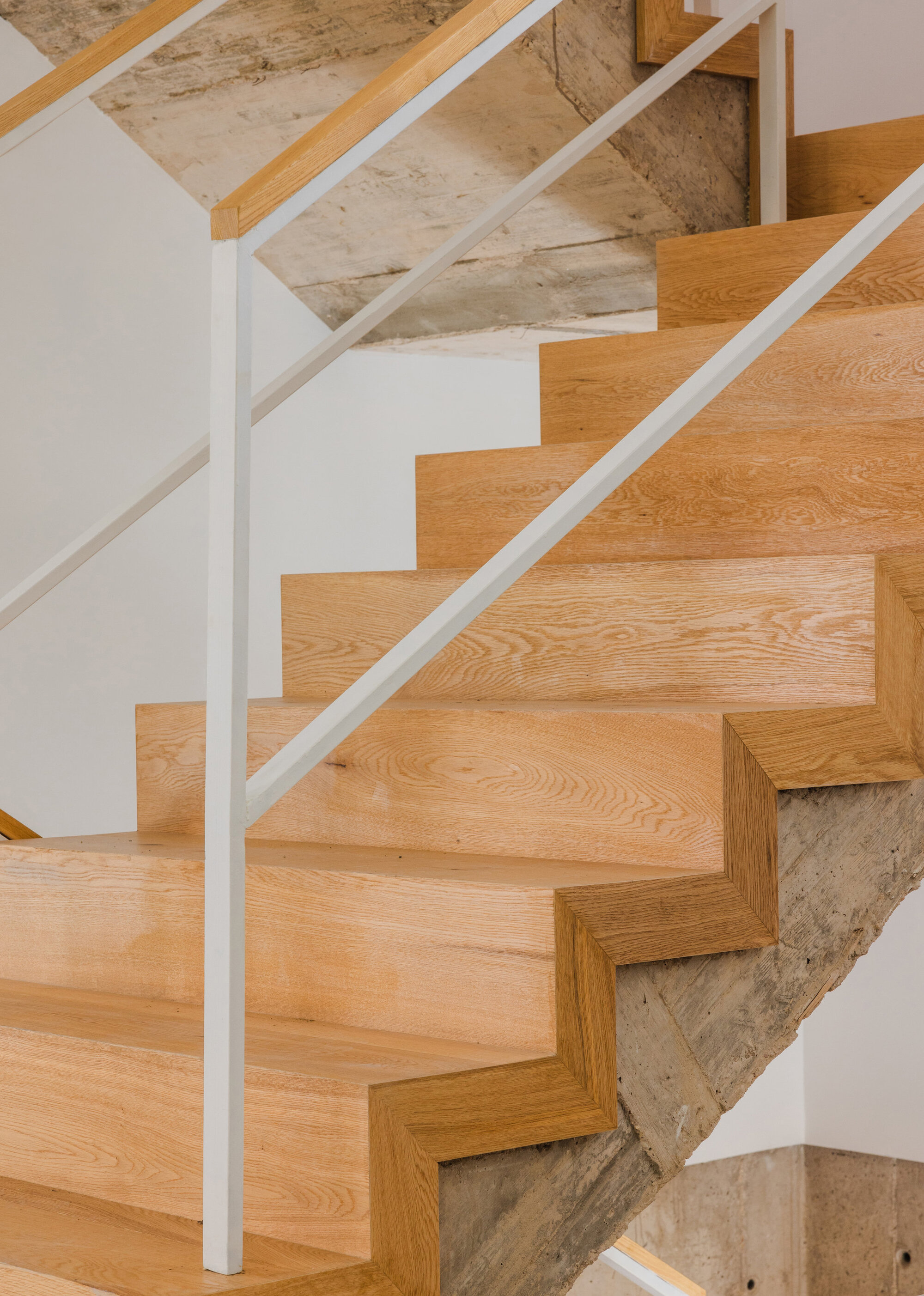 View up oak treads showing the intersection between new timber and retained concrete stringer