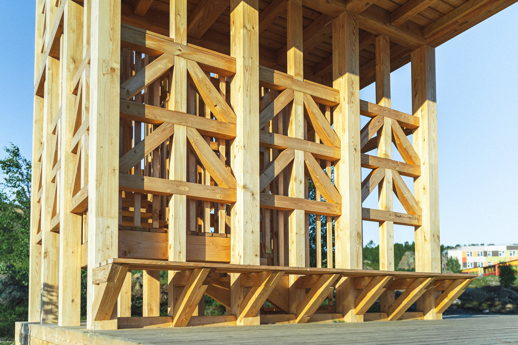 Interior view of exposed timber framing with diagonal bracing and vertical posts under an open ceiling