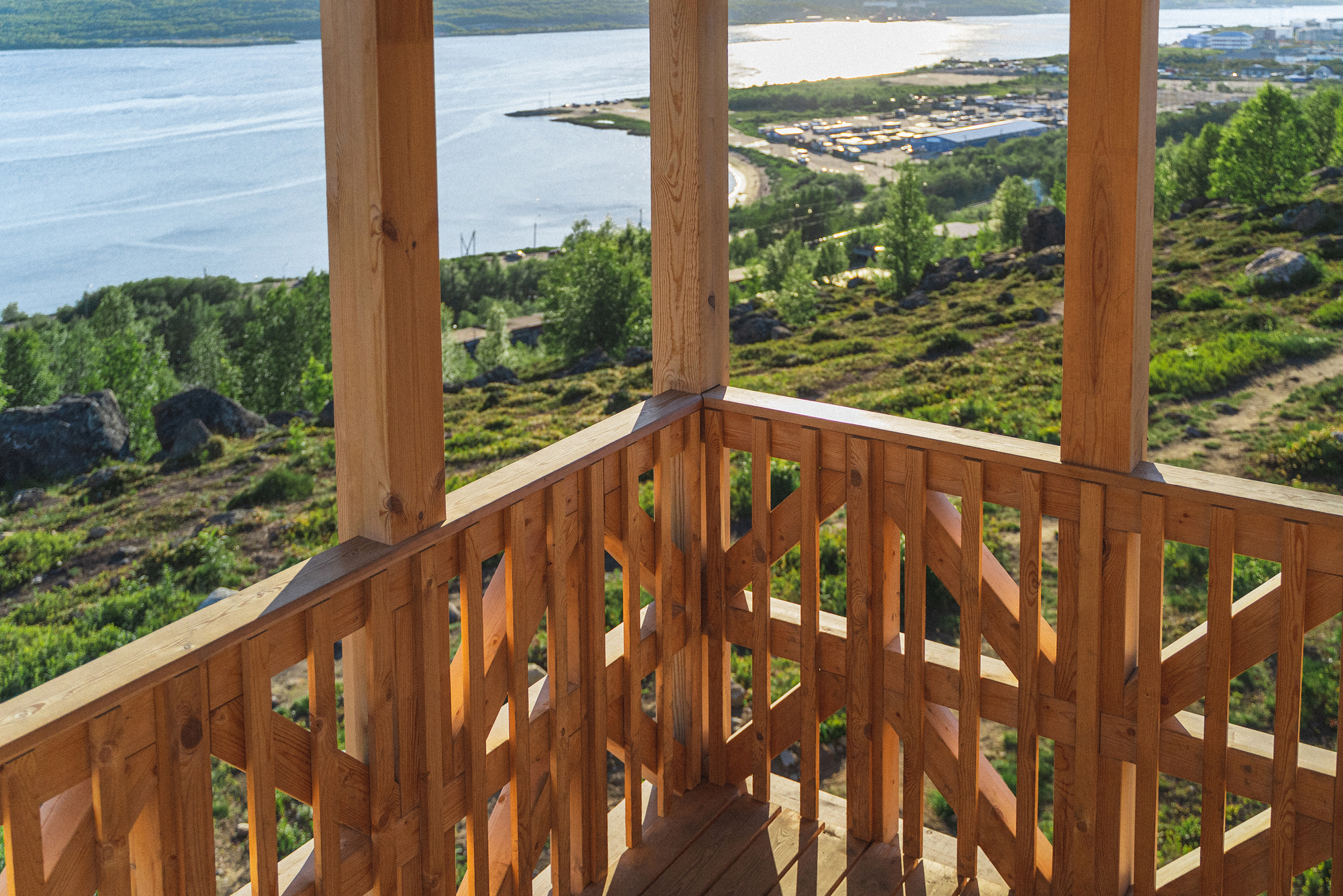 Corner detail of the open timber railing with triangular cutouts framing the valley below