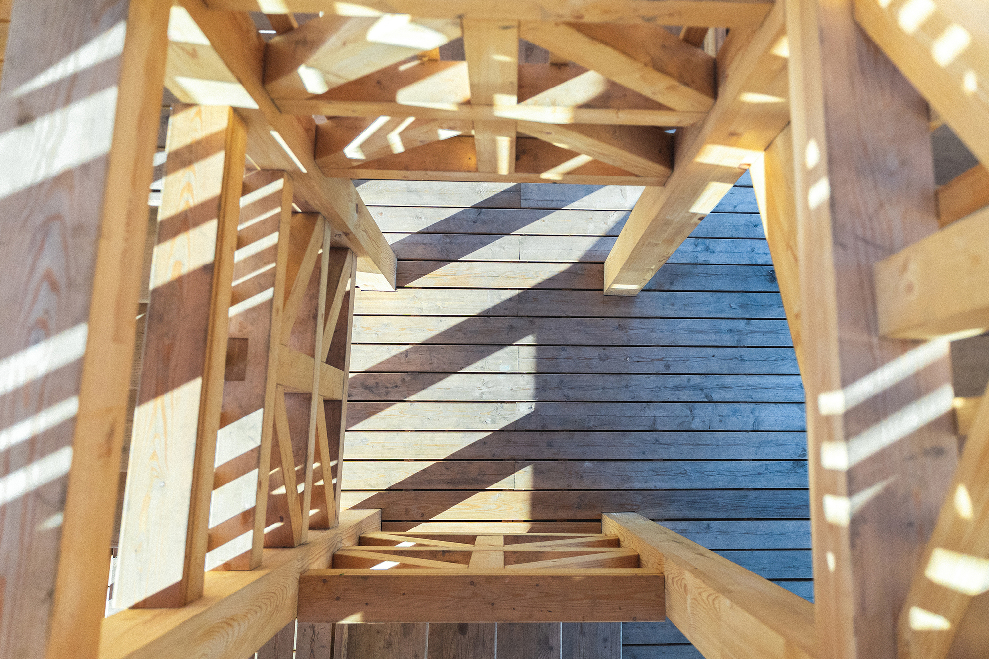 Looking up through the timber frame at painted wooden cladding in blue and grey tones