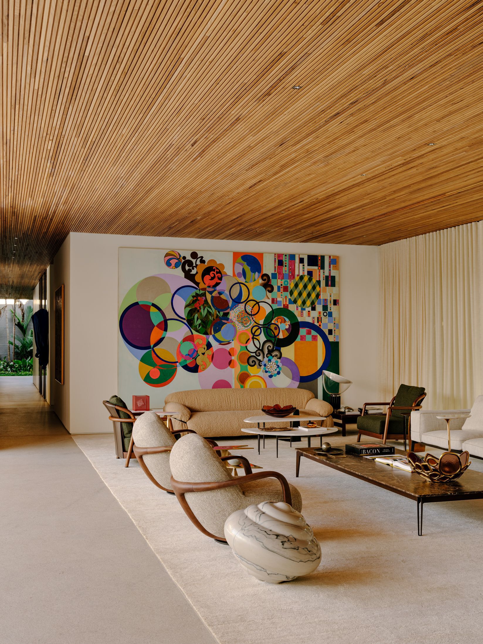 Living room with continuous slatted timber ceiling and a large abstract mural on the rear wall