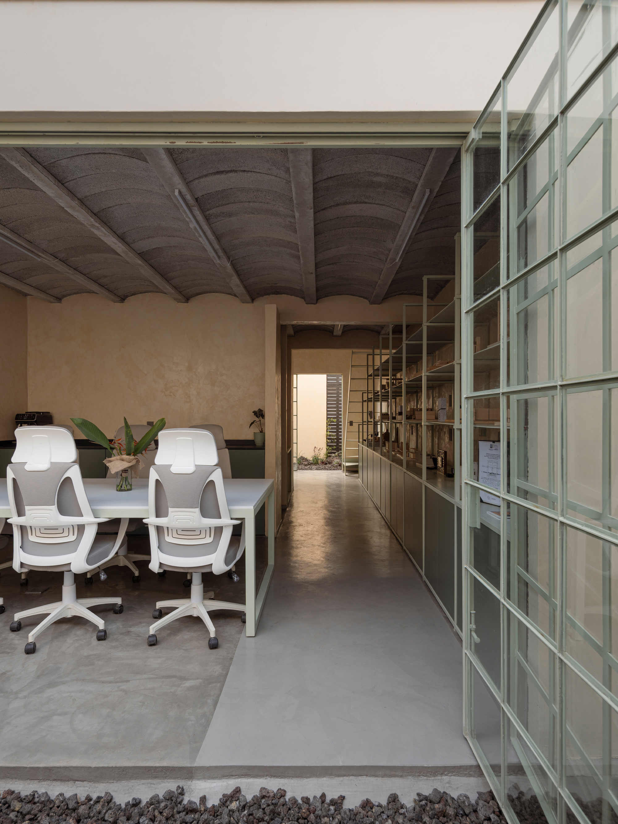 Office corridor with polished concrete floor, exposed beam ceiling and translucent glass wall along one side