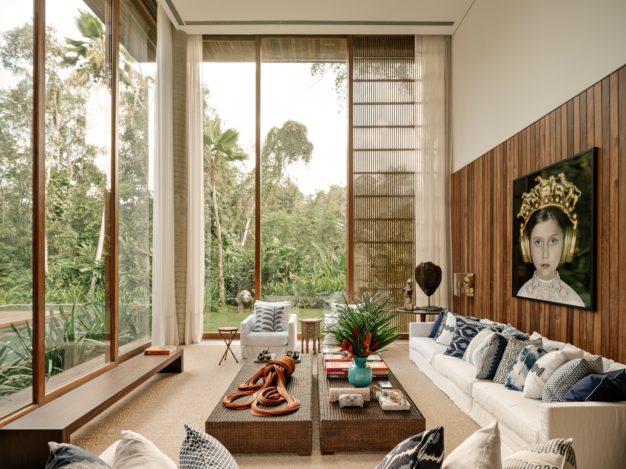 Double-height living room with floor-to-ceiling glazing, vertical timber slat screen, and view to garden