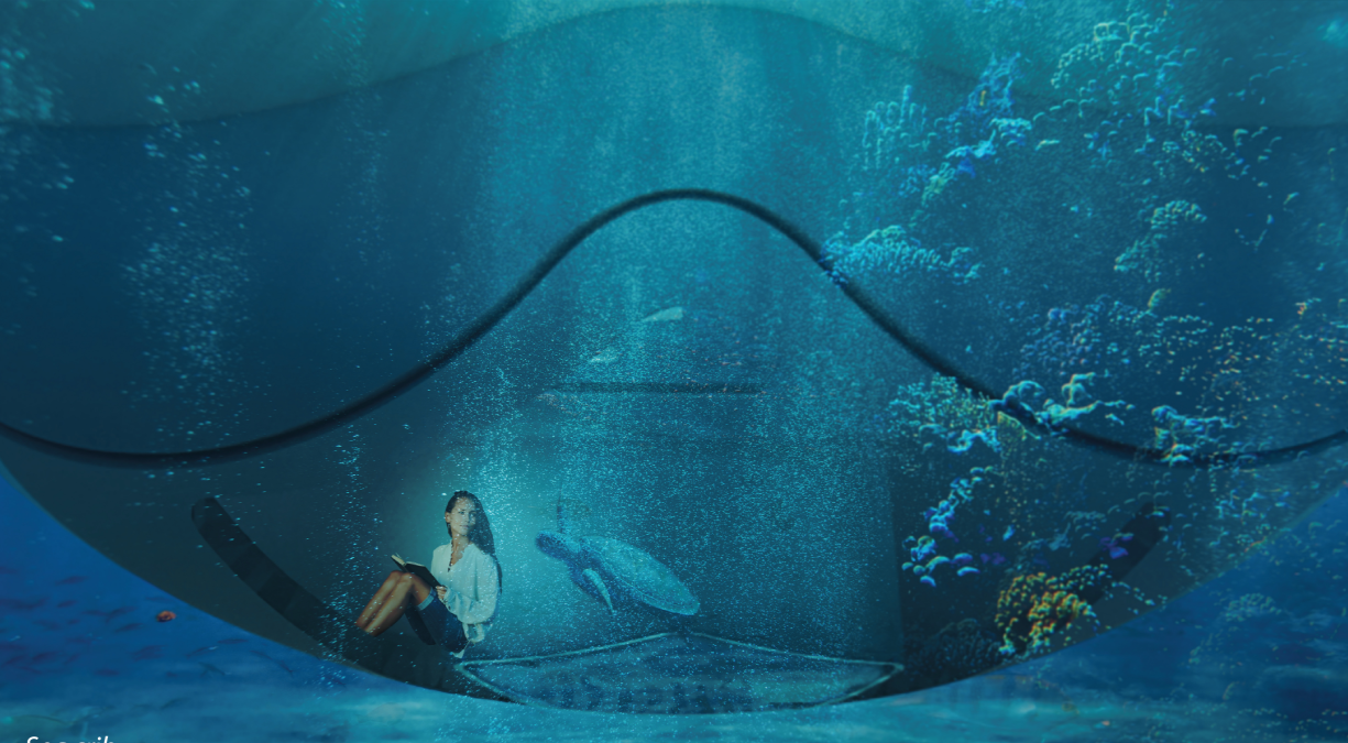 Submerged seating nook beneath curved transparent canopy with person reading while diver explores coral outside