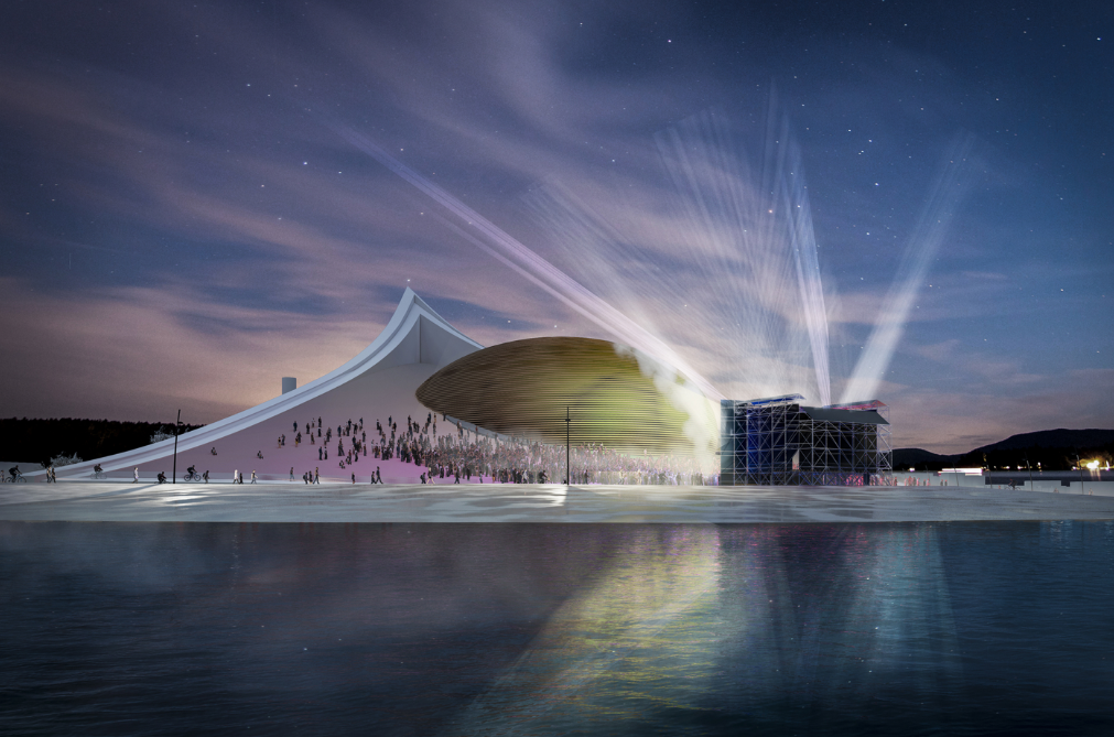 Evening view of the sculpted roof and waterfront plaza with light beams projecting into the twilight sky