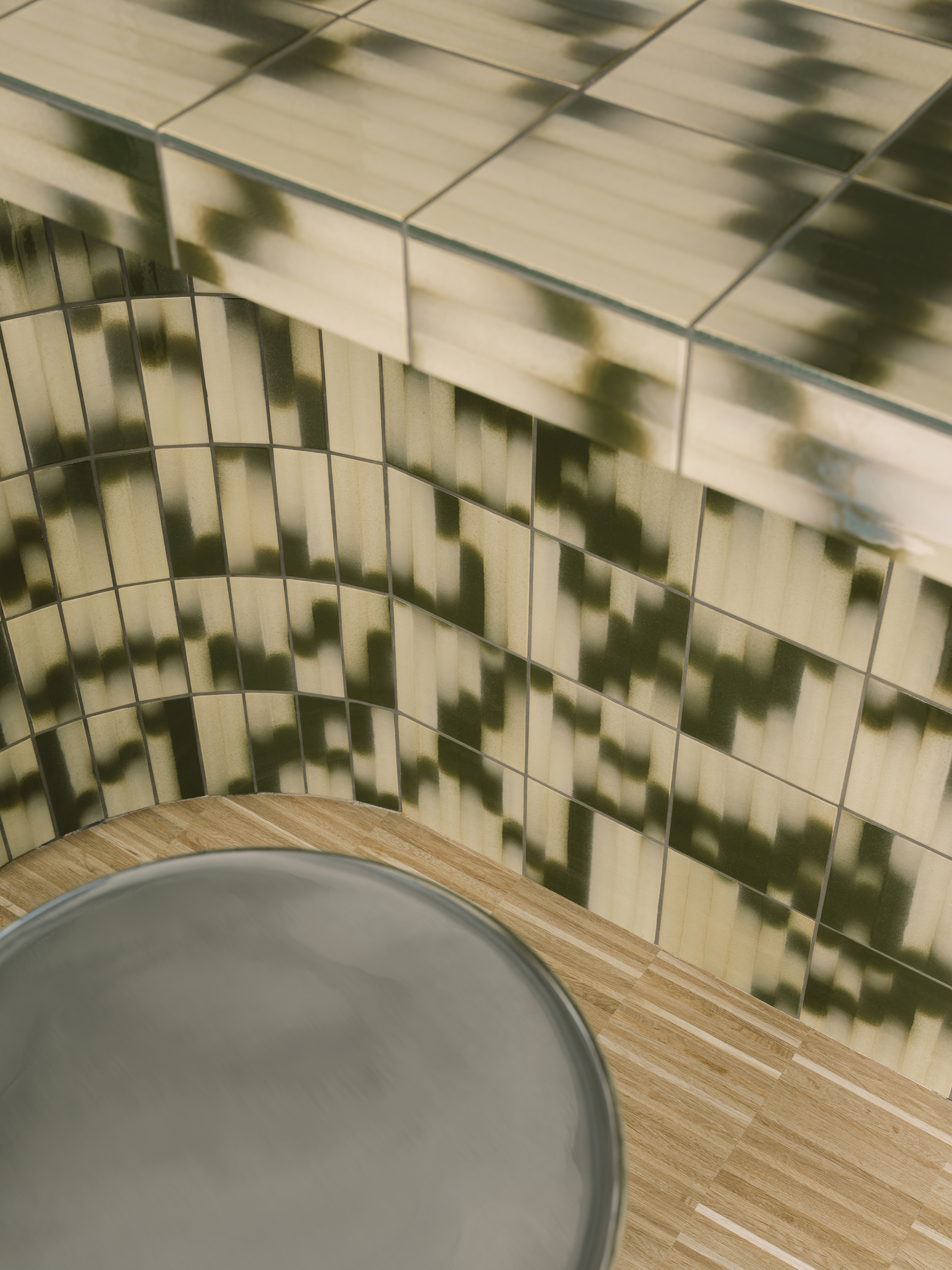 Corner detail of cream-tiled wall with dappled shadow patterns cast across horizontal subway tiles