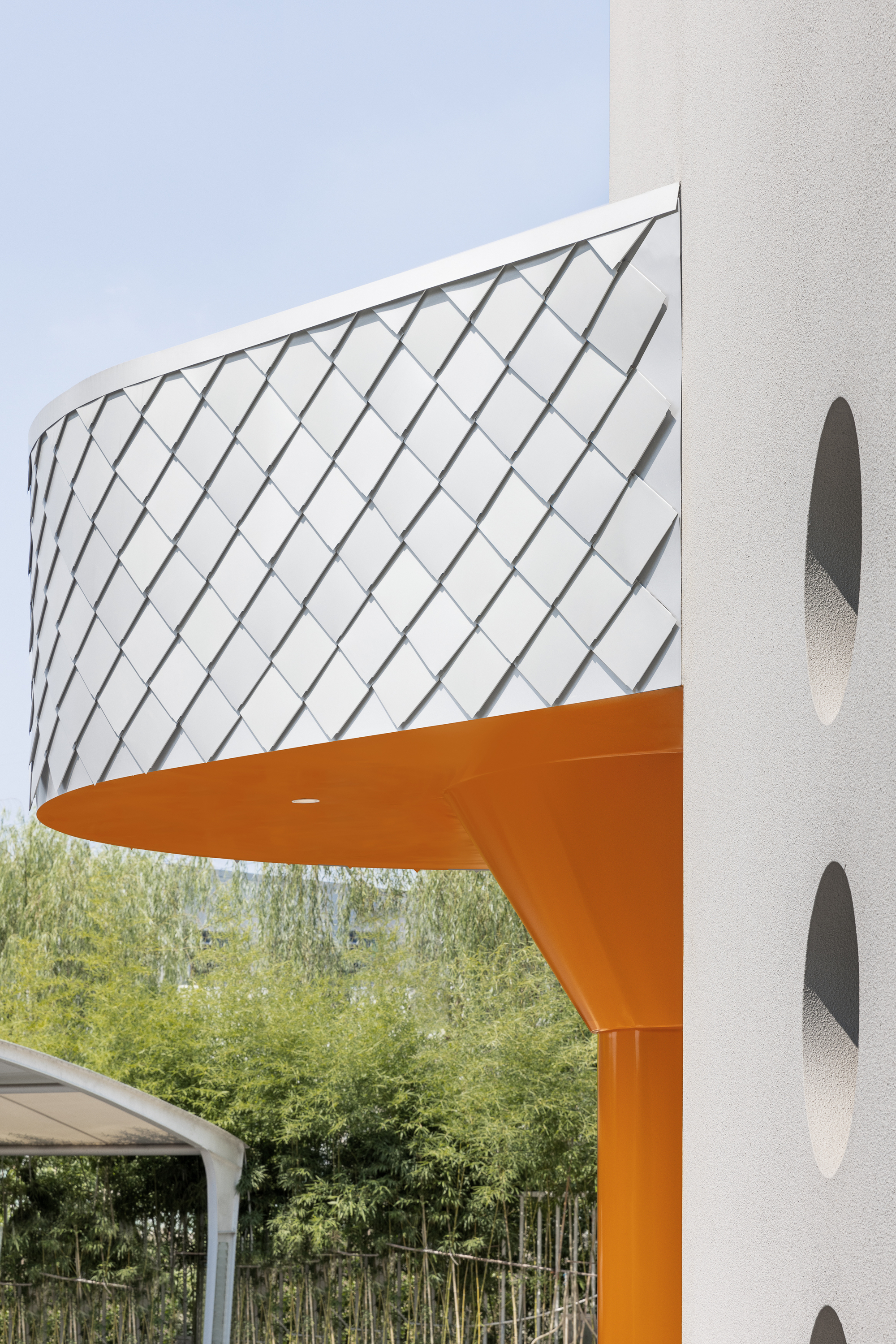 Detail of the diagonal metal cladding canopy edge supported by an orange steel column