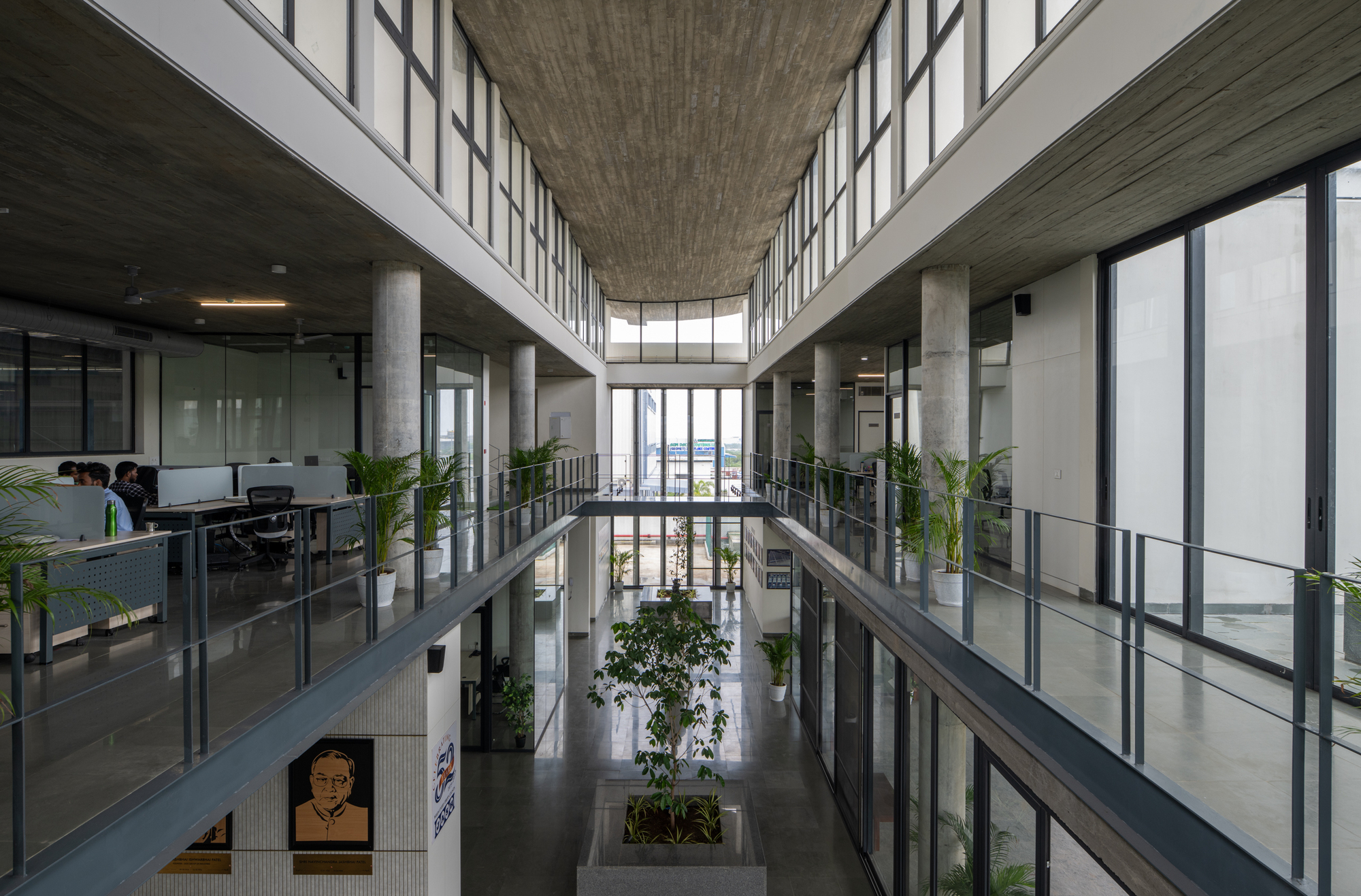 Central atrium corridor with glazed office frontages on three levels and planted interior beds below