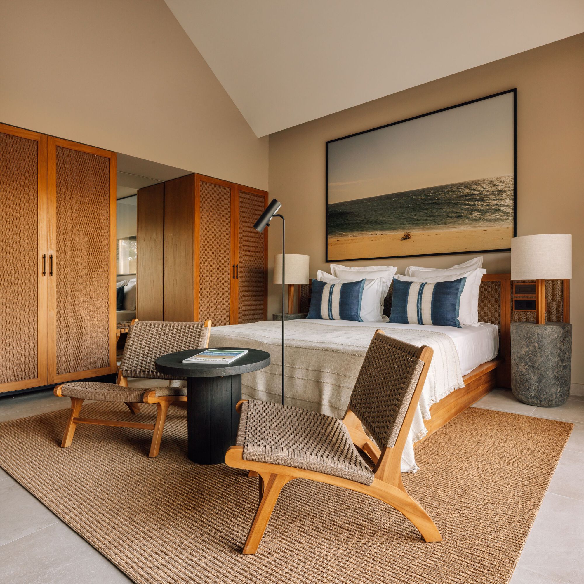 Bedroom with woven-panel timber wardrobes and vaulted ceiling above the platform bed