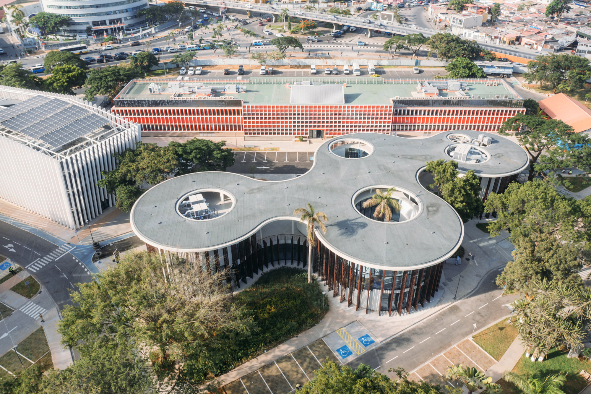 Aerial view of interconnected circular volumes with central oculi arranged across a landscaped plaza