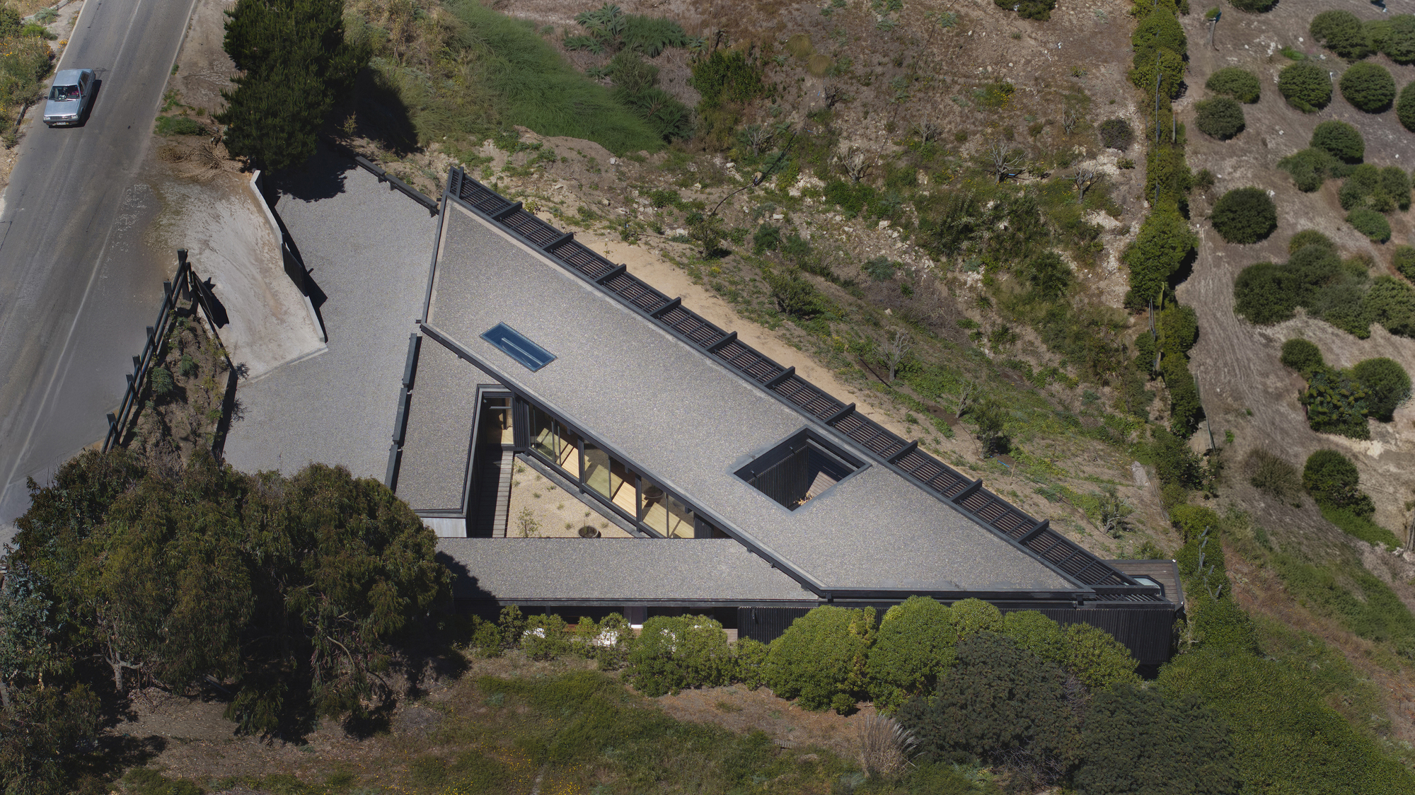 Overhead view of the triangular roof with central skylight and dark membrane roofing