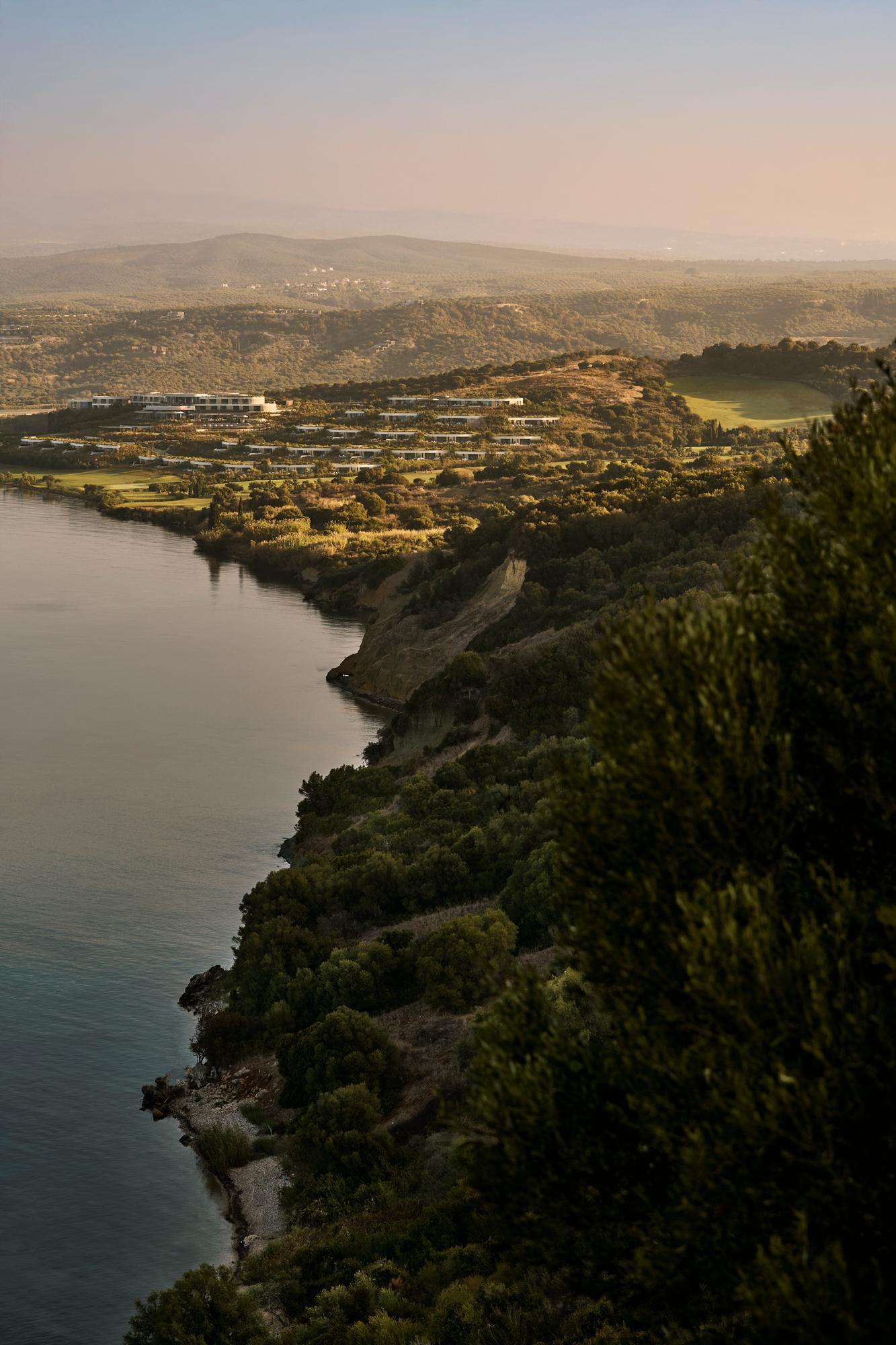 Terraced landscape stepping down a hillside toward a lake at golden hour