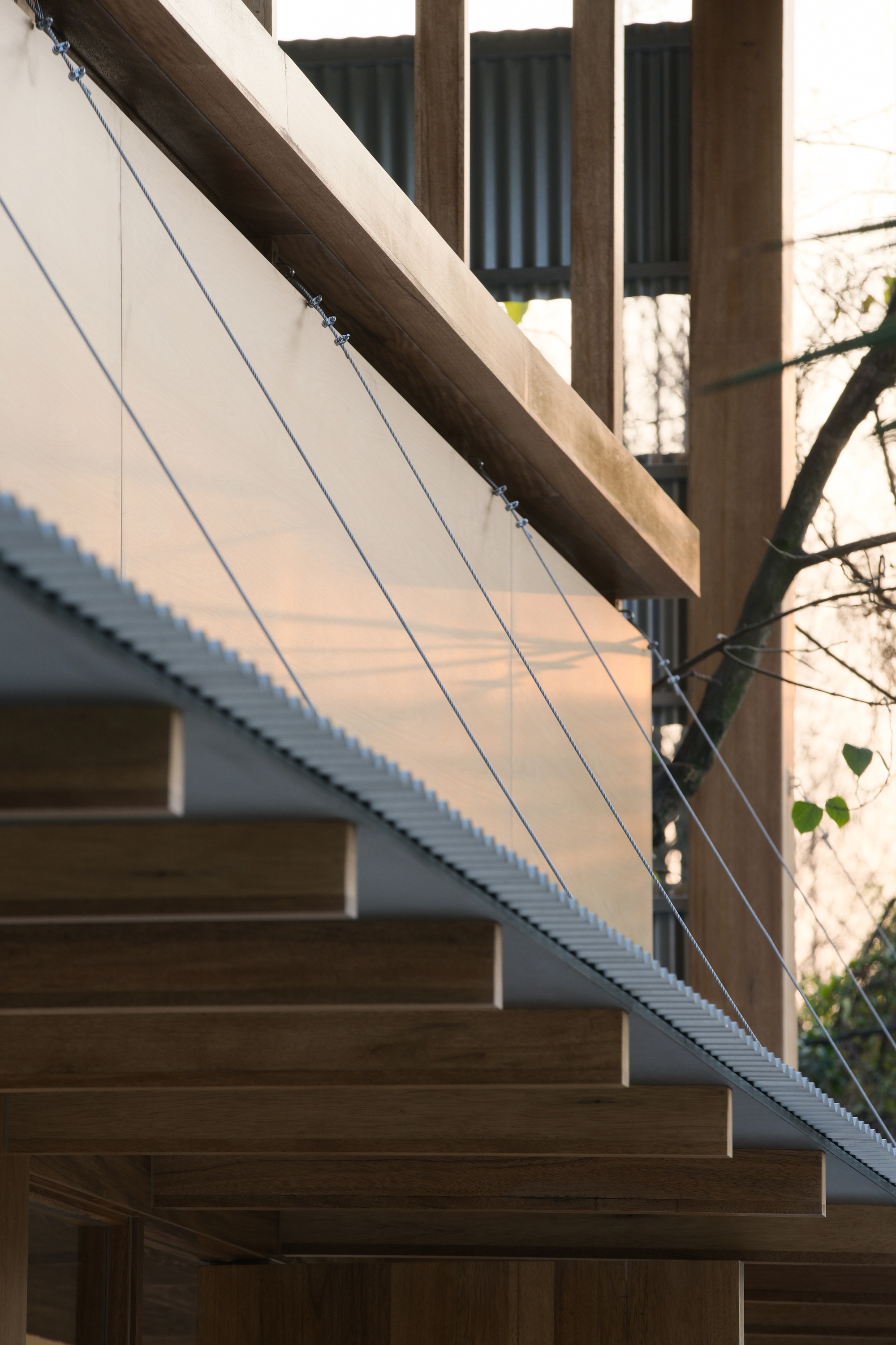 Underside of corrugated roof panel with timber rafters at dusk