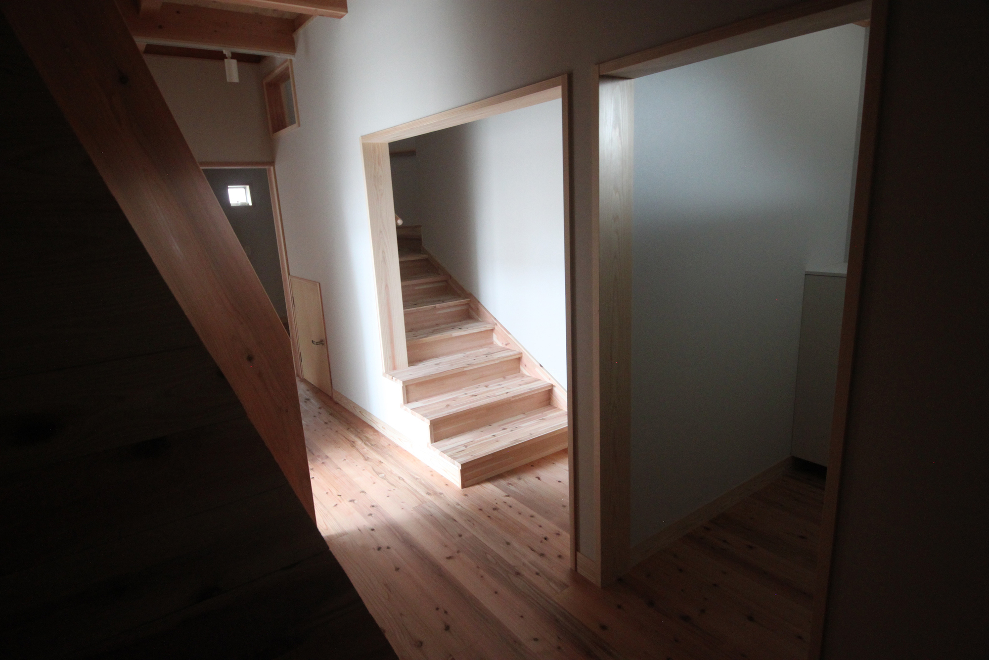 Timber staircase framed by white walls and timber doorways under diffused natural light