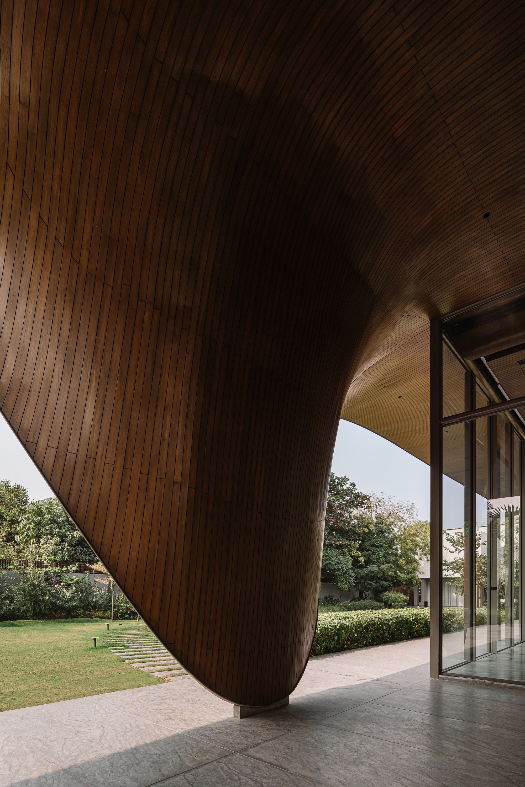 Covered terrace showing the sculptural underside of the timber-lined roof meeting the floor