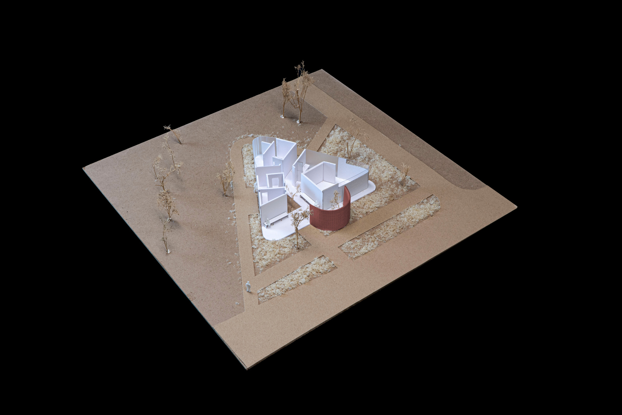 Physical model showing the clustered volumes beneath the lifted triangular roof with a central cylindrical core